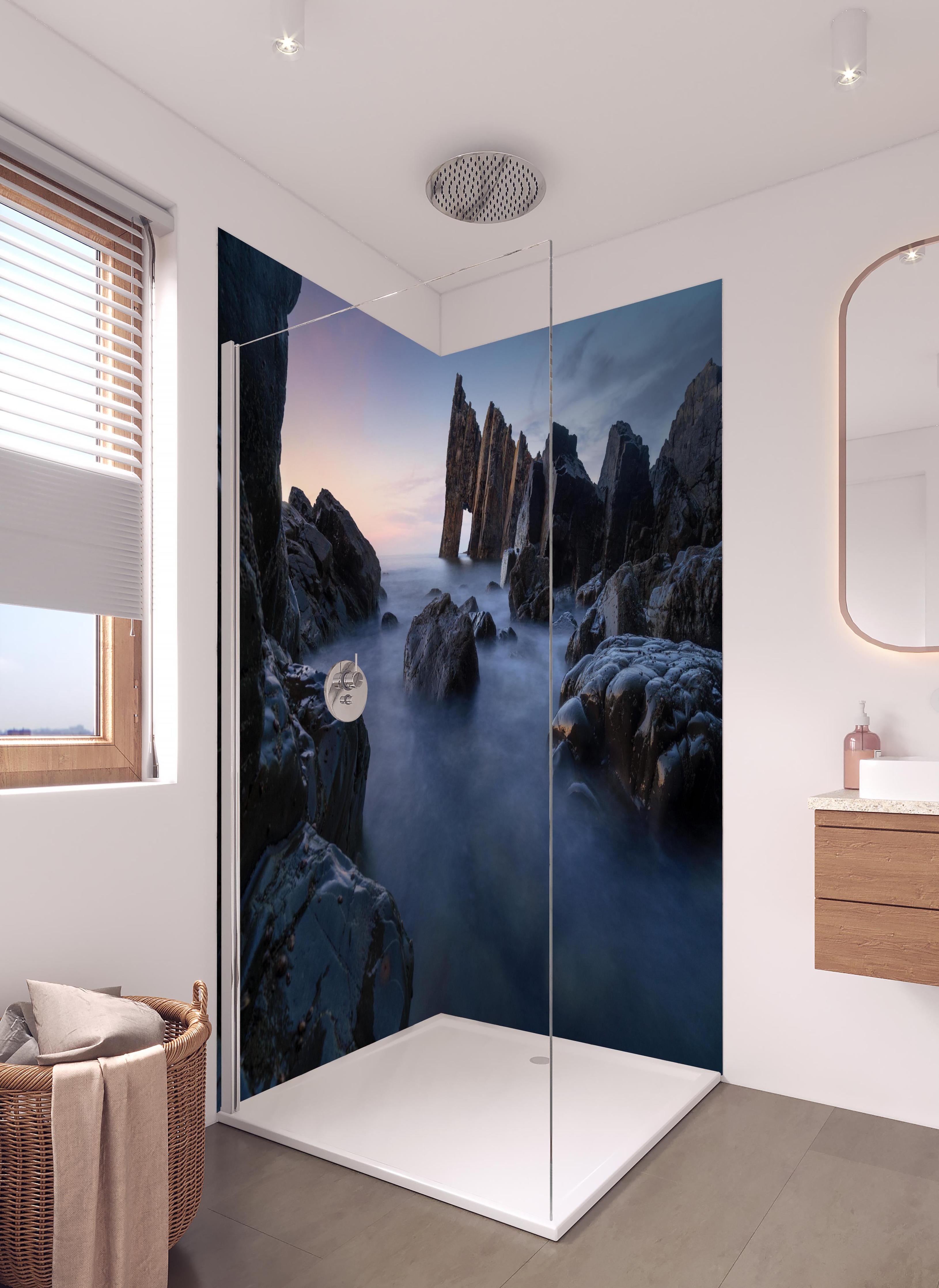 Duschrückwand - Sonnenuntergang am felsigen Meeresufer in hellem Badezimmer mit Regenduschkopf - zweiteilige Eck-Duschrückwand