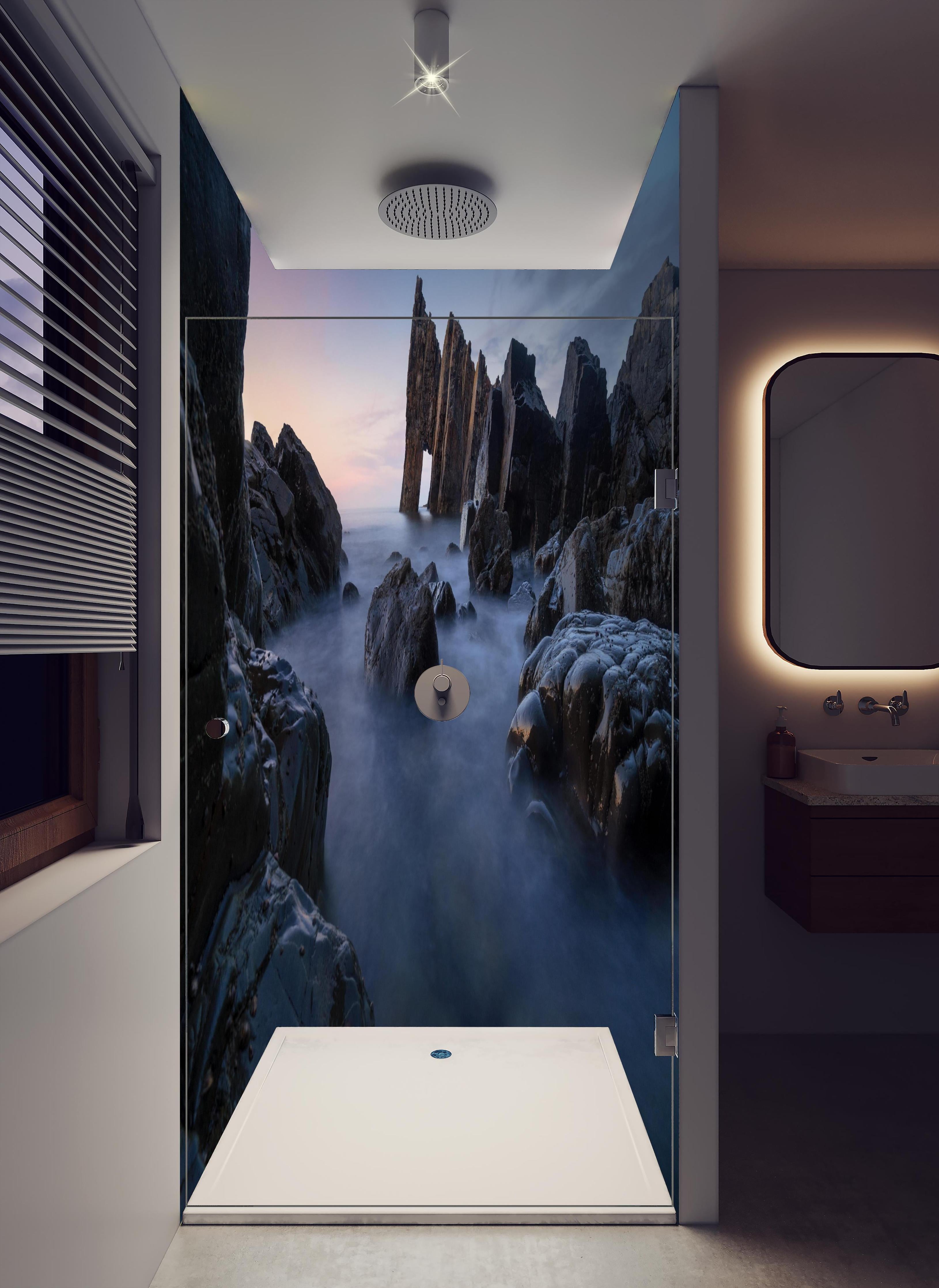 Duschrückwand - Sonnenuntergang am felsigen Meeresufer in hellem Badezimmer mit Regenduschkopf - zweiteilige Eck-Duschrückwand