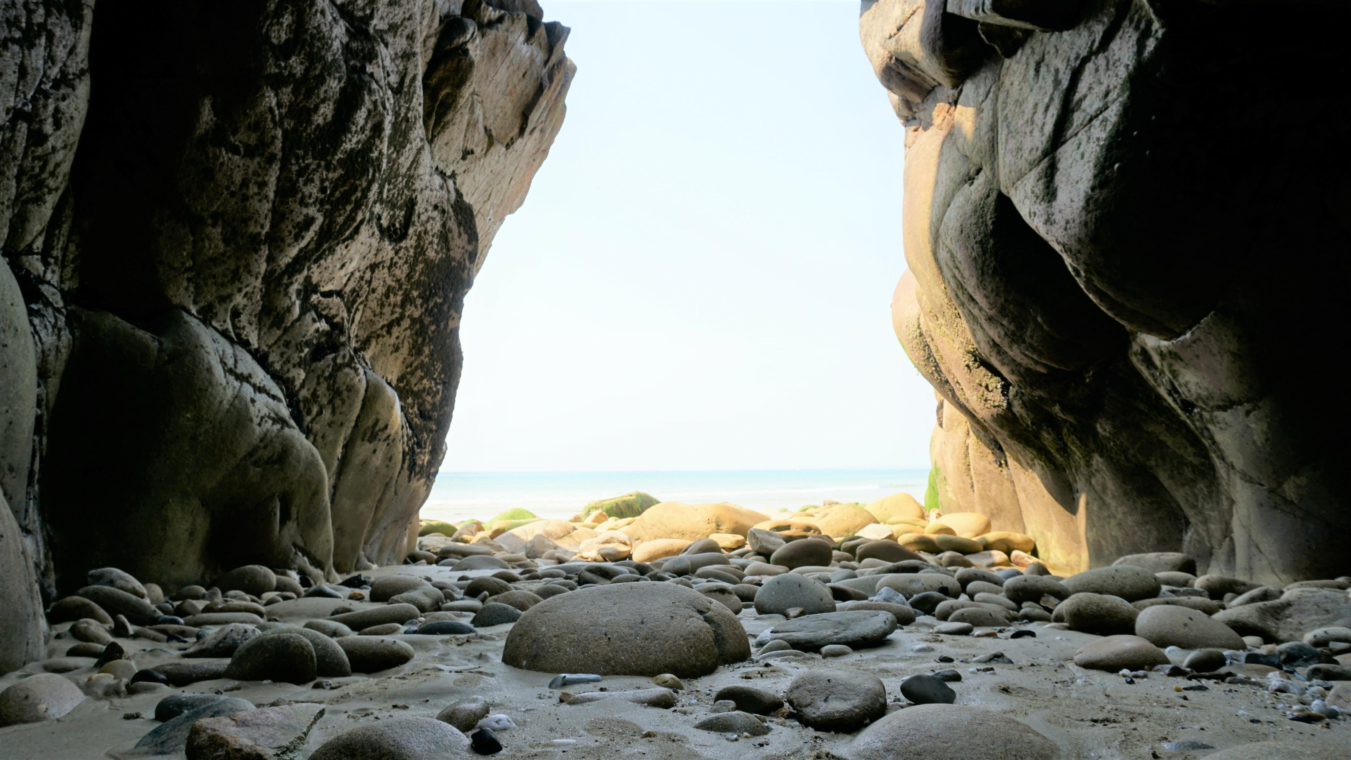 Duschrückwand-Steinstrand zwischen Felsen an Küste