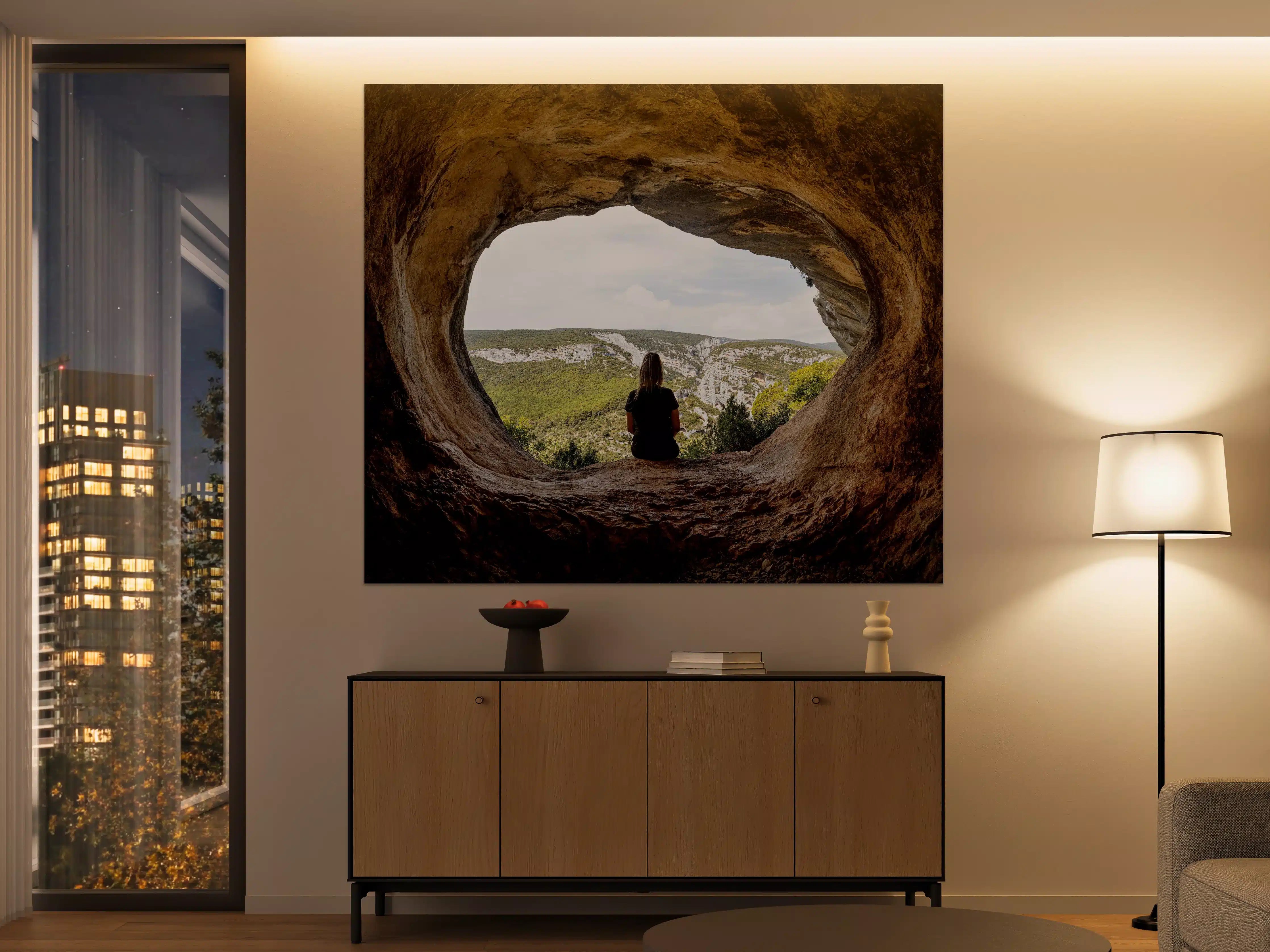 Große Wandbilder - Frau sitzend in Berghöhle mit Blick auf Landschaft