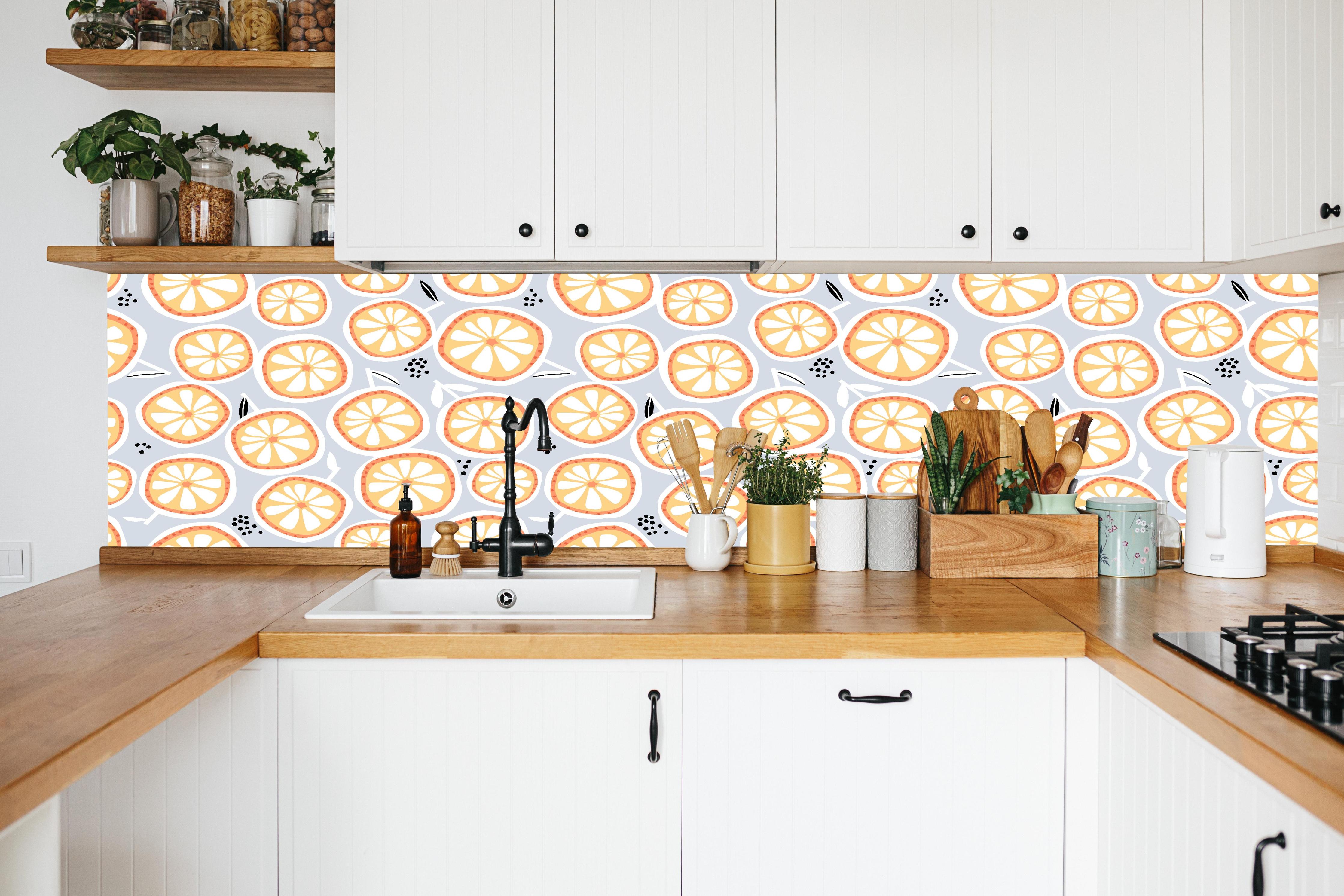 Küche - Citrus-Orange Küchenrückwand in weißer Küche hinter Gewürzen und Kochlöffeln aus Holz