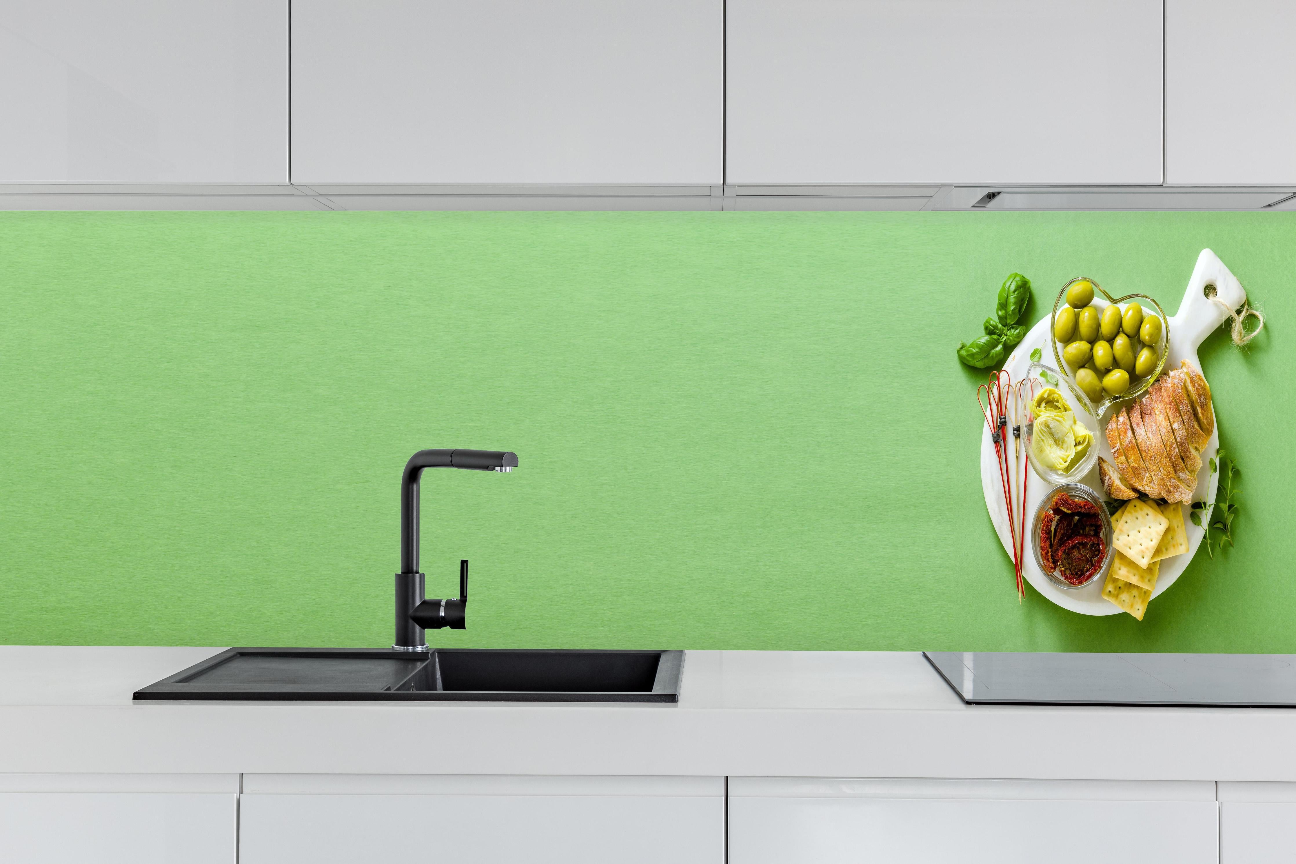 Küche - Grüne Küchenrückwand mit Oliven hinter weißen Hochglanz-Küchenregalen und schwarzem Wasserhahn