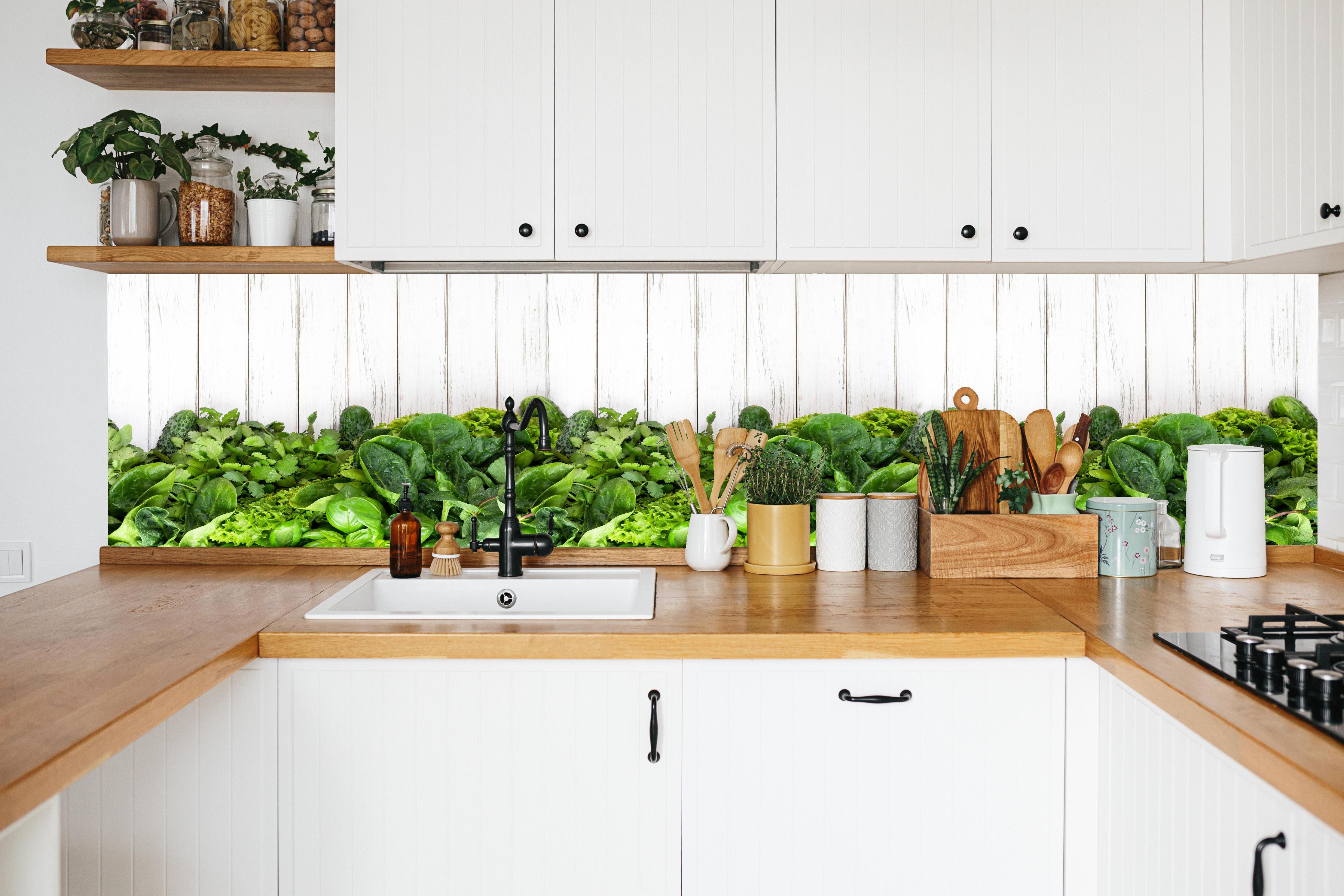 Küche - Weiß-Grün Kräuter Küchenrückwand in weißer Küche hinter Gewürzen und Kochlöffeln aus Holz