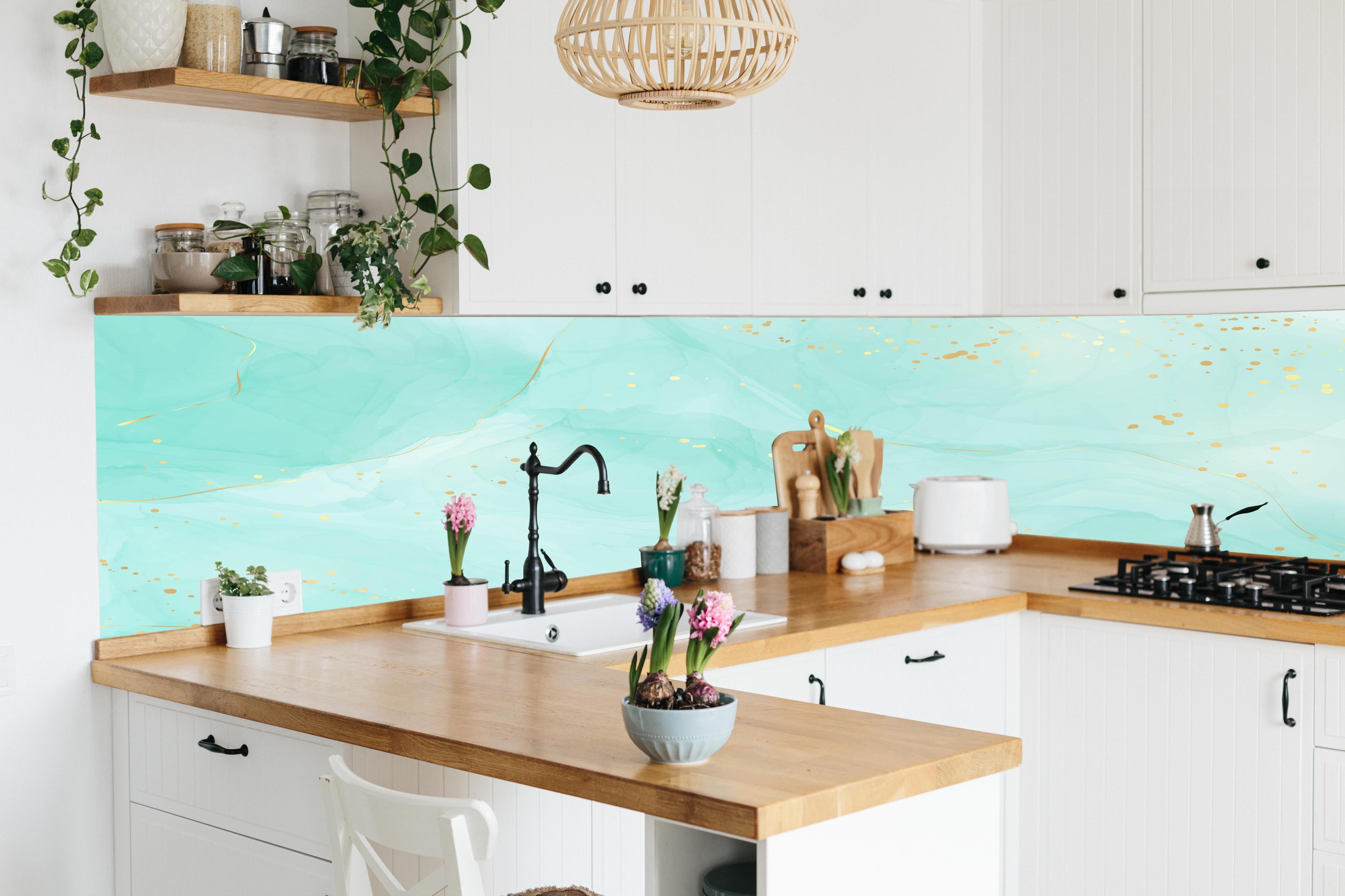 Küche - Abstrakte Aquarell-Kunst in Türkis mit Goldakzenten hinter weißen Hochglanz-Küchenregalen und schwarzem Wasserhahn