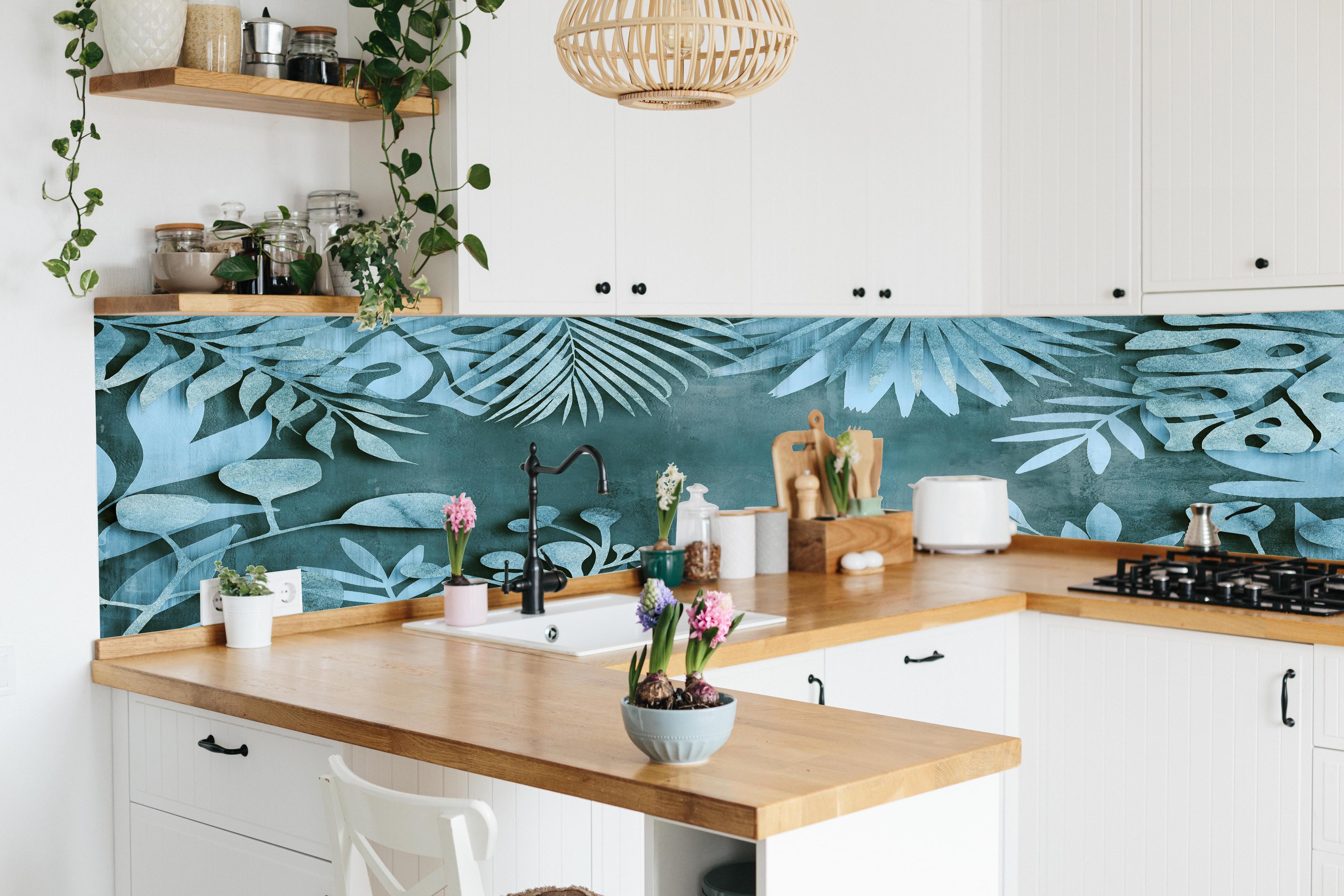 Küche - Abstrakte Blatt-Strukturen in Türkisblau hinter weißen Hochglanz-Küchenregalen und schwarzem Wasserhahn