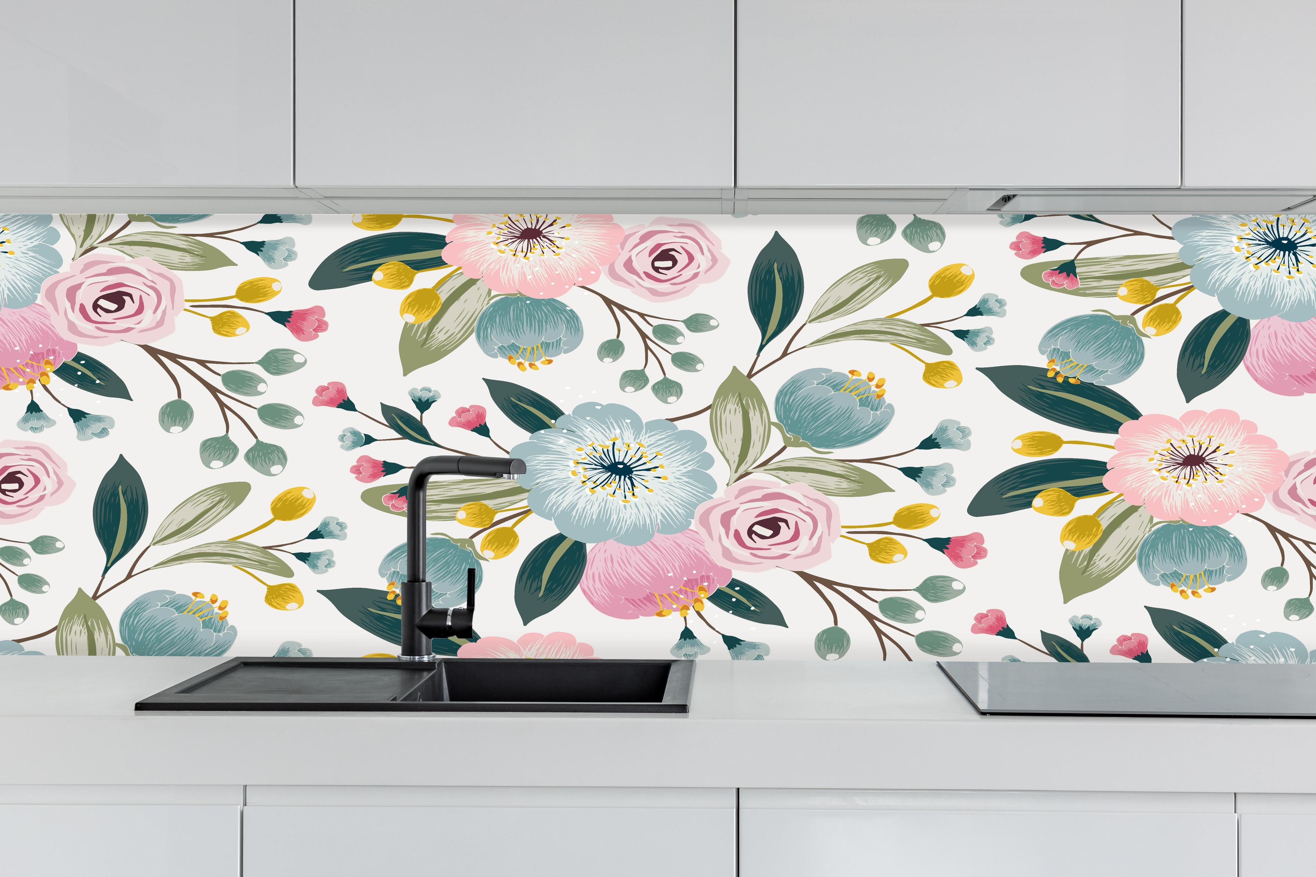 Küche - Abstrakte Blumenmuster in Rosa und Hellblau hinter weißen Hochglanz-Küchenregalen und schwarzem Wasserhahn