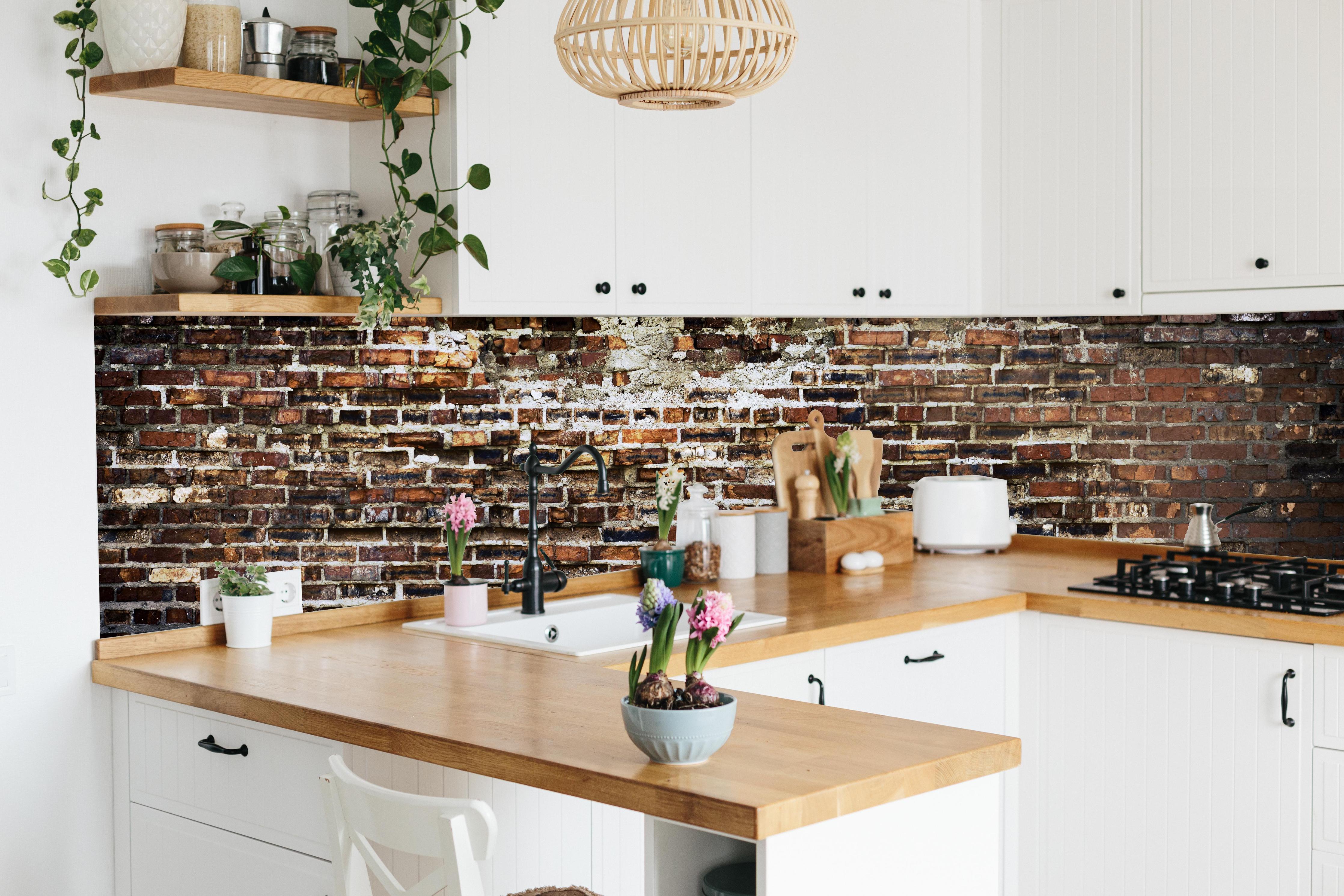 Küche - Alte Rote Ziegelwand mit Verputz hinter weißen Hochglanz-Küchenregalen und schwarzem Wasserhahn