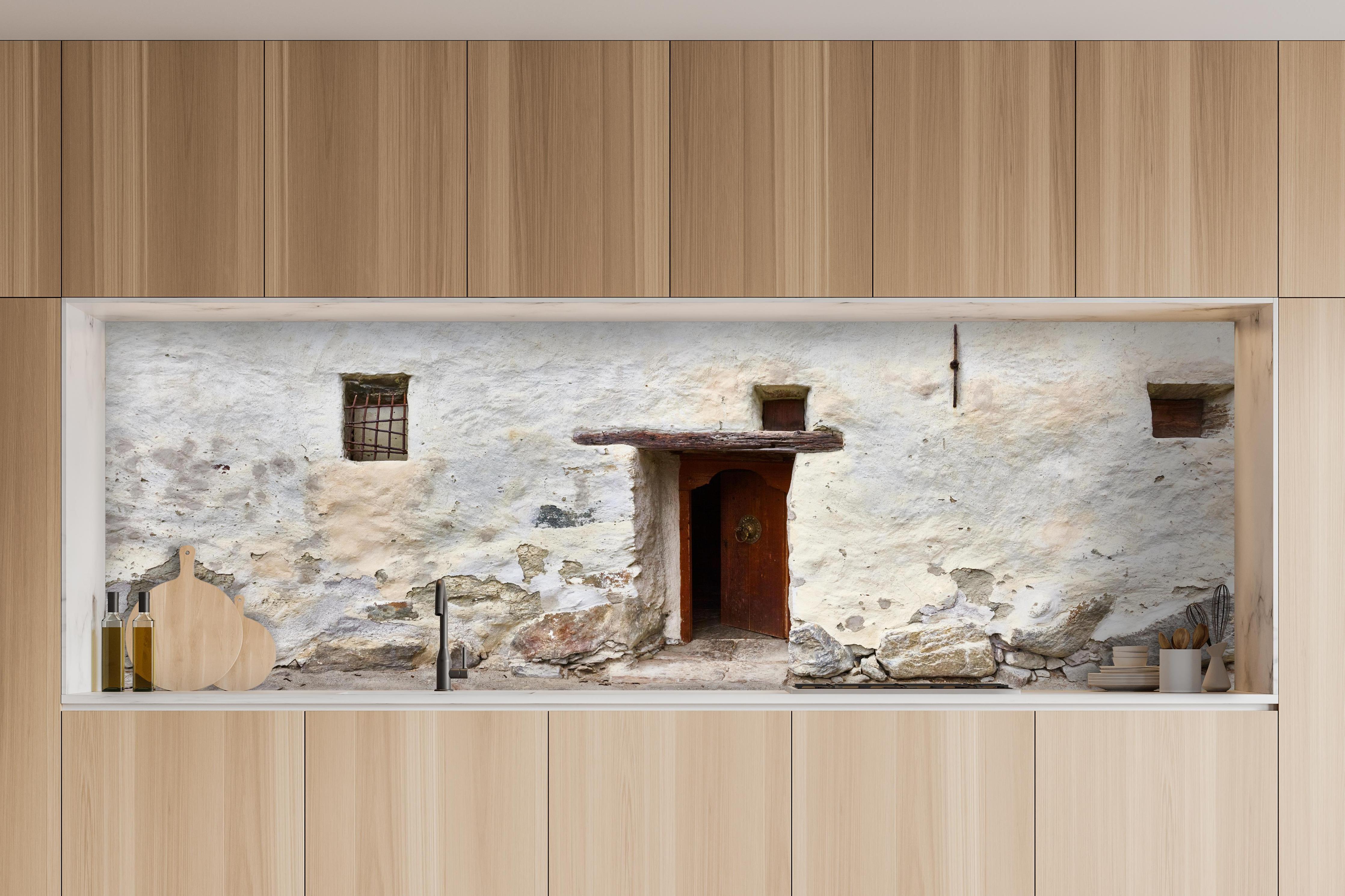 Küche - Alter Türeingang in Südtirol hinter weißen Hochglanz-Küchenregalen und schwarzem Wasserhahn