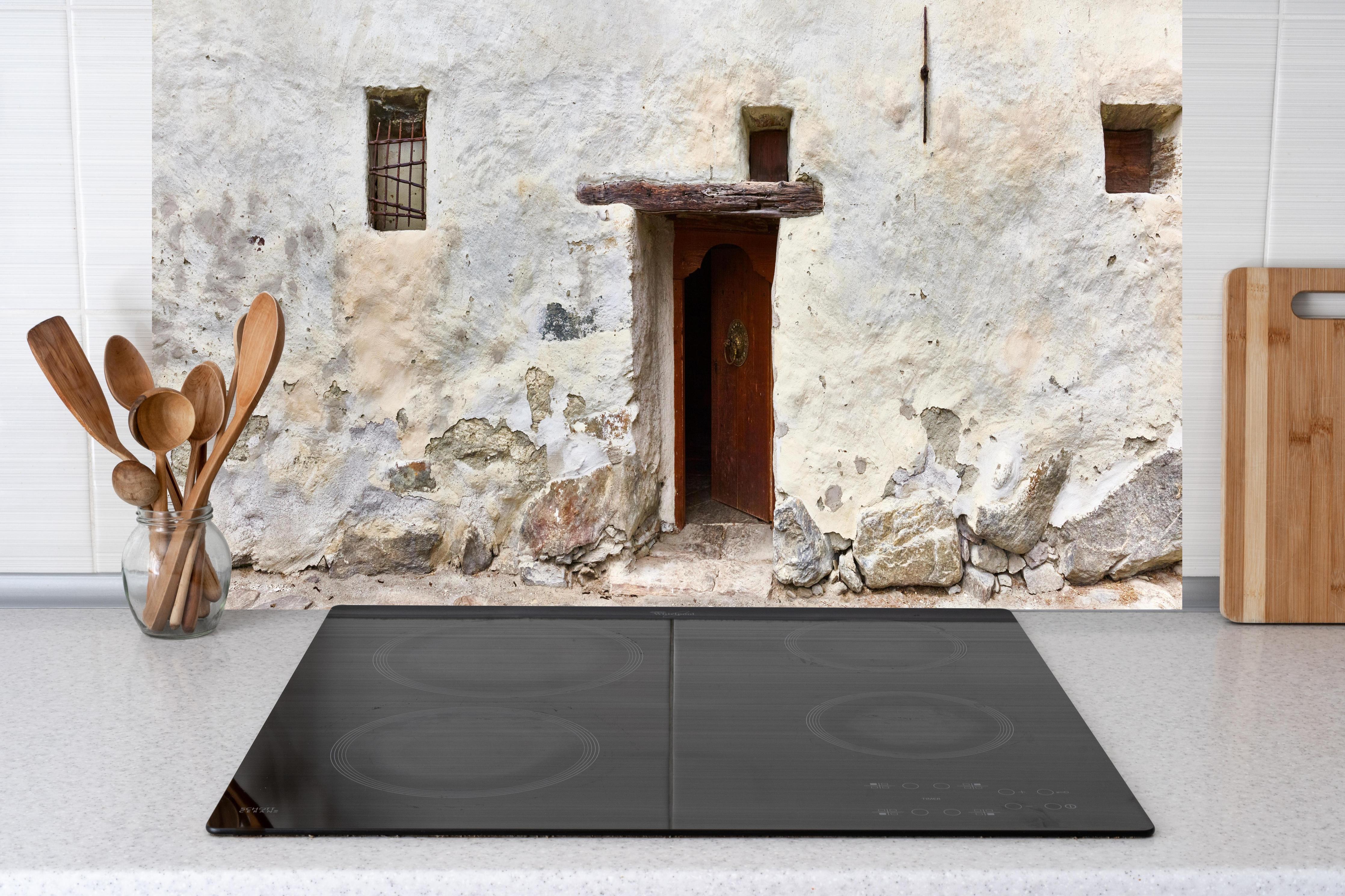 Küche - Alter Türeingang in Südtirol hinter weißen Hochglanz-Küchenregalen und schwarzem Wasserhahn