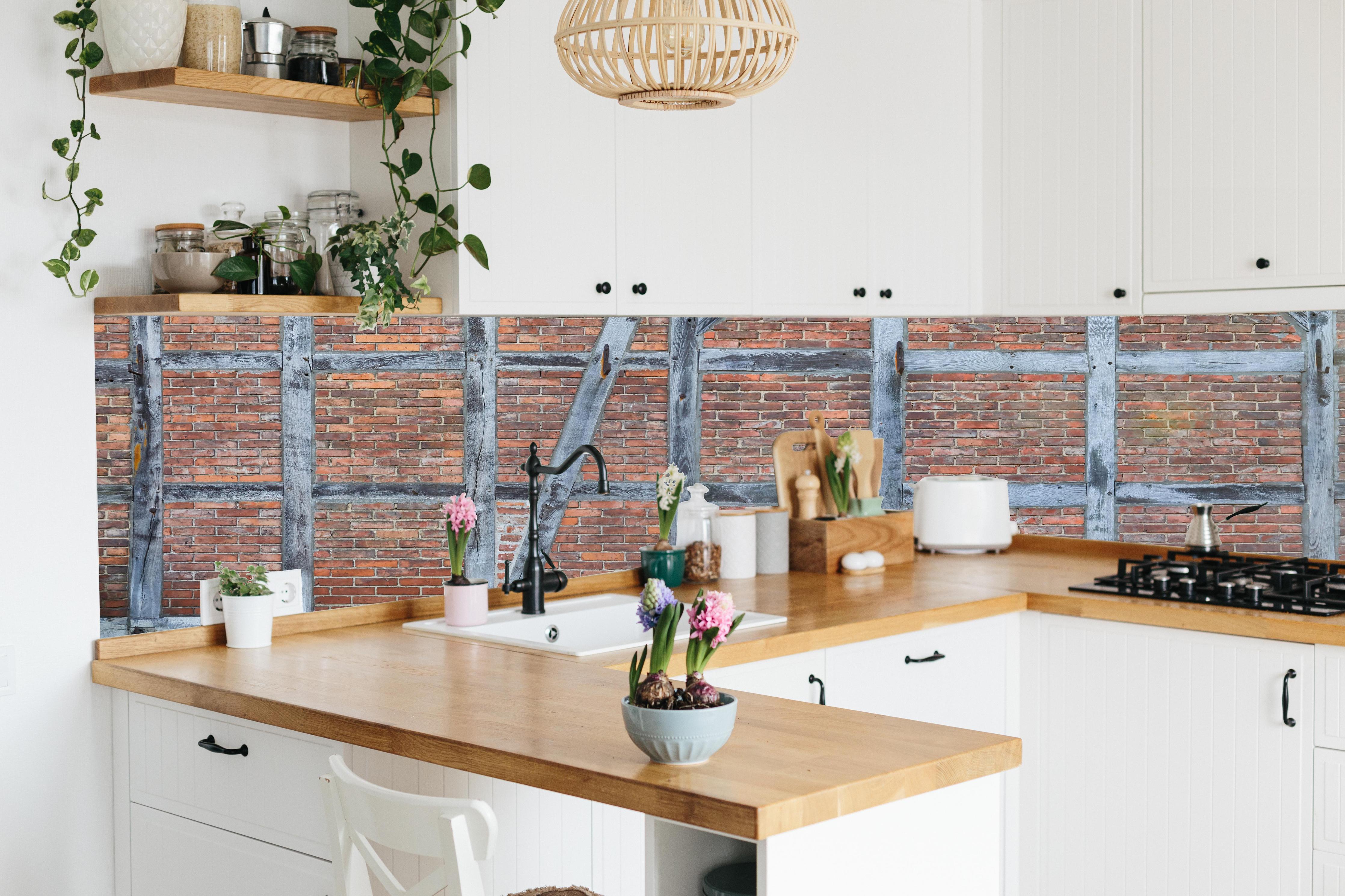 Küche - Altmodische Wand aus Niedersachen hinter weißen Hochglanz-Küchenregalen und schwarzem Wasserhahn