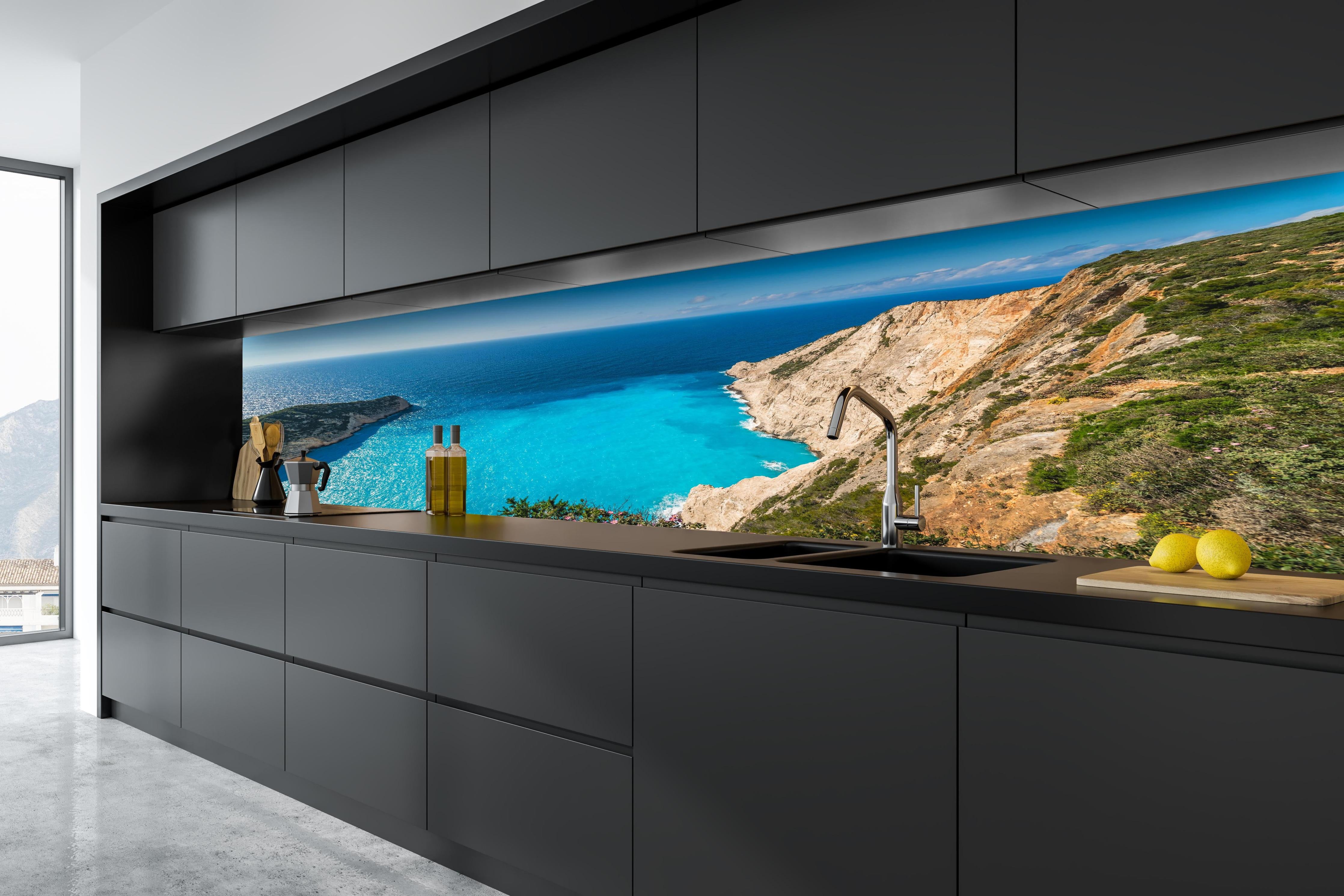 Küche - Atemberaubende Aussicht auf türkisblaue Küstenlandschaft hinter weißen Hochglanz-Küchenregalen und schwarzem Wasserhahn