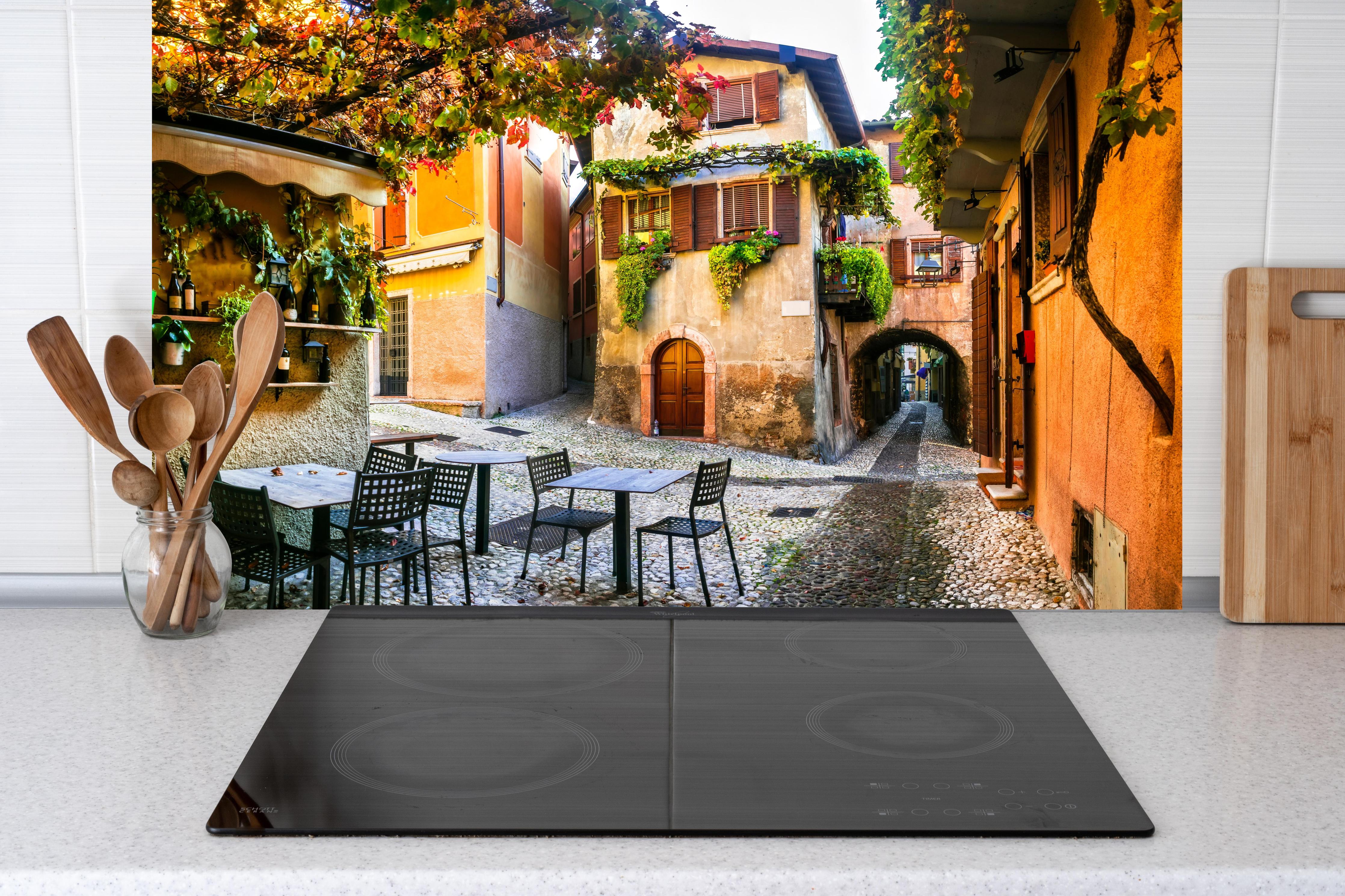 Küche - Bezaubernde alte Gasse in Malcesine hinter weißen Hochglanz-Küchenregalen und schwarzem Wasserhahn