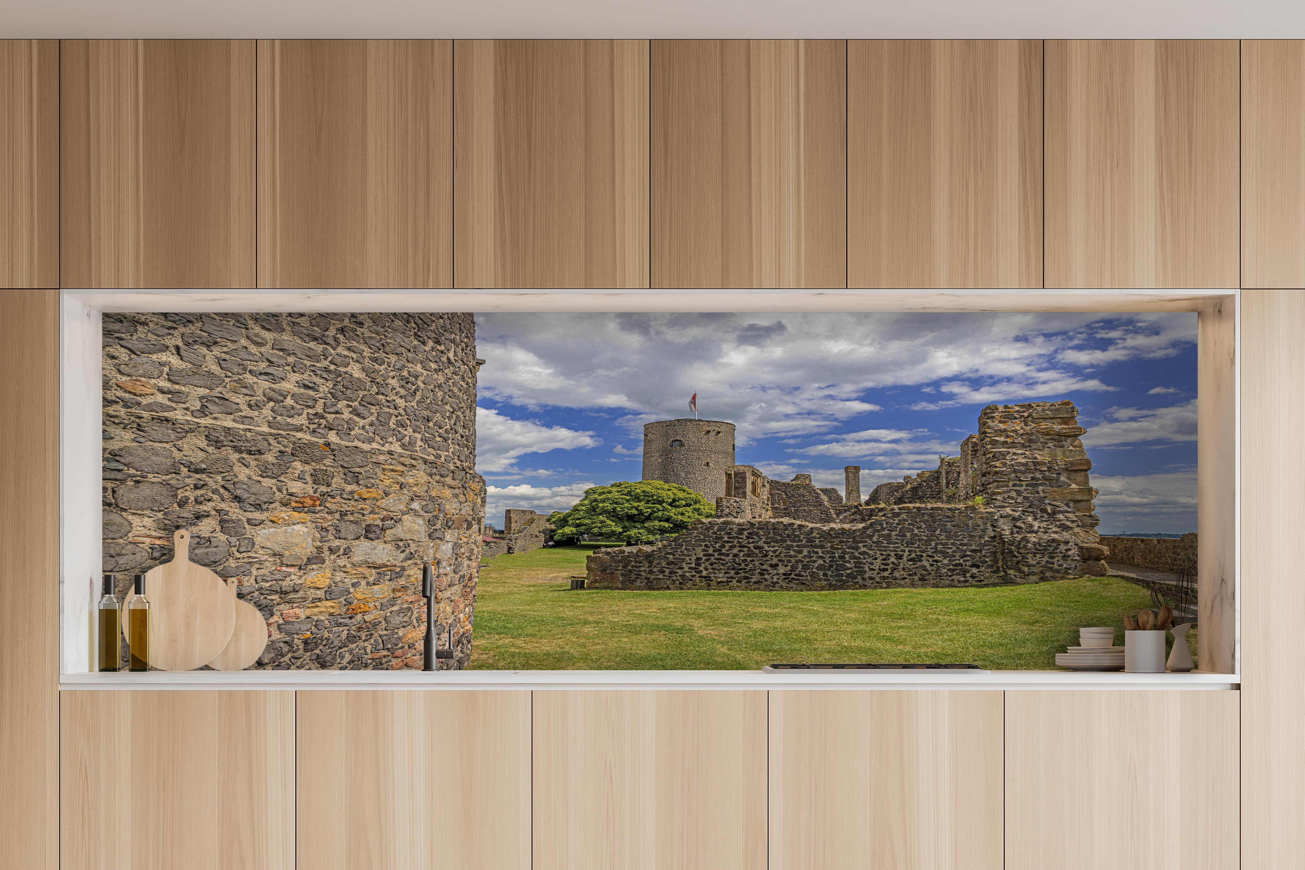 Küche - Bild von der Burgruine Münzenberg in Hessen hinter weißen Hochglanz-Küchenregalen und schwarzem Wasserhahn