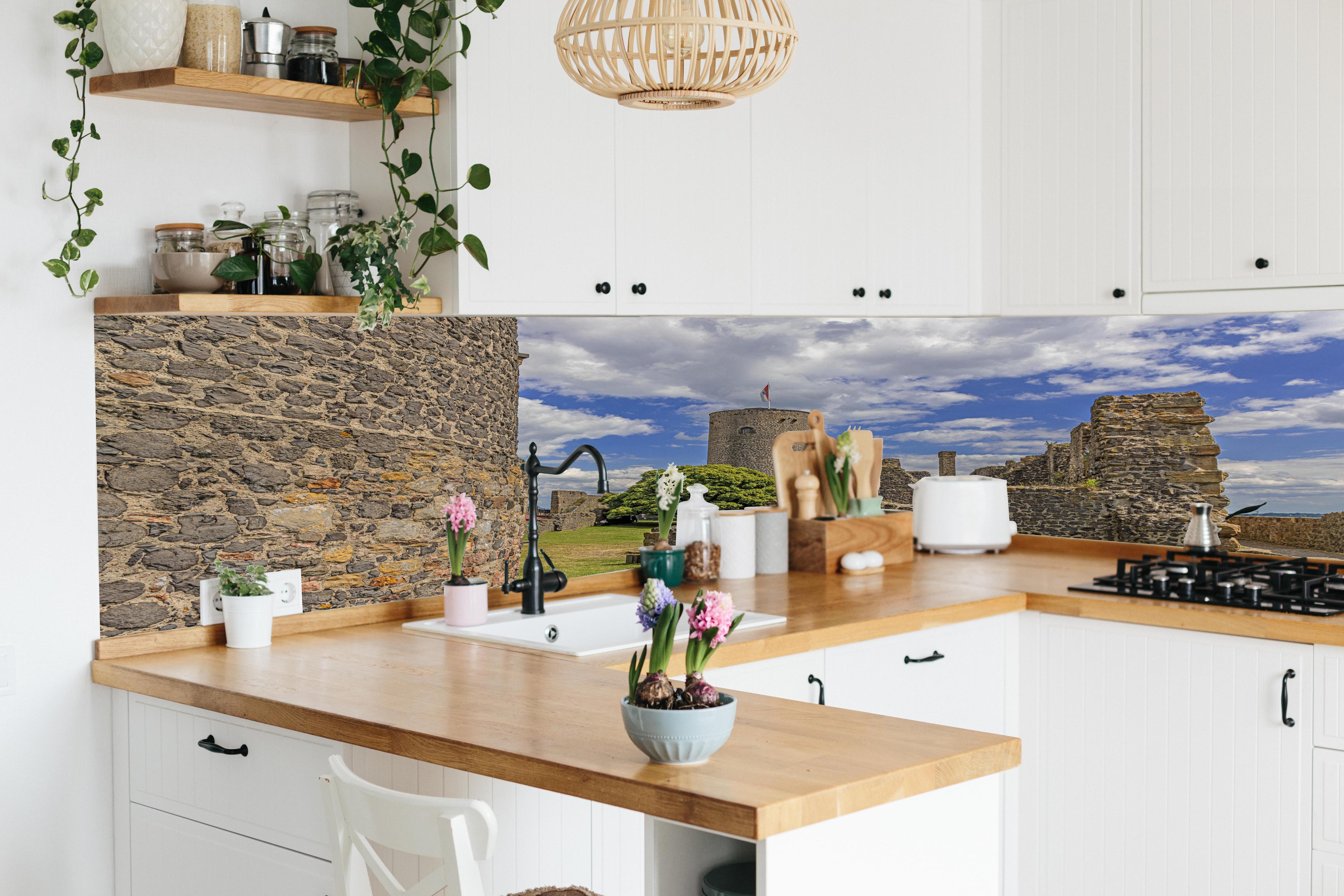 Küche - Bild von der Burgruine Münzenberg in Hessen hinter weißen Hochglanz-Küchenregalen und schwarzem Wasserhahn