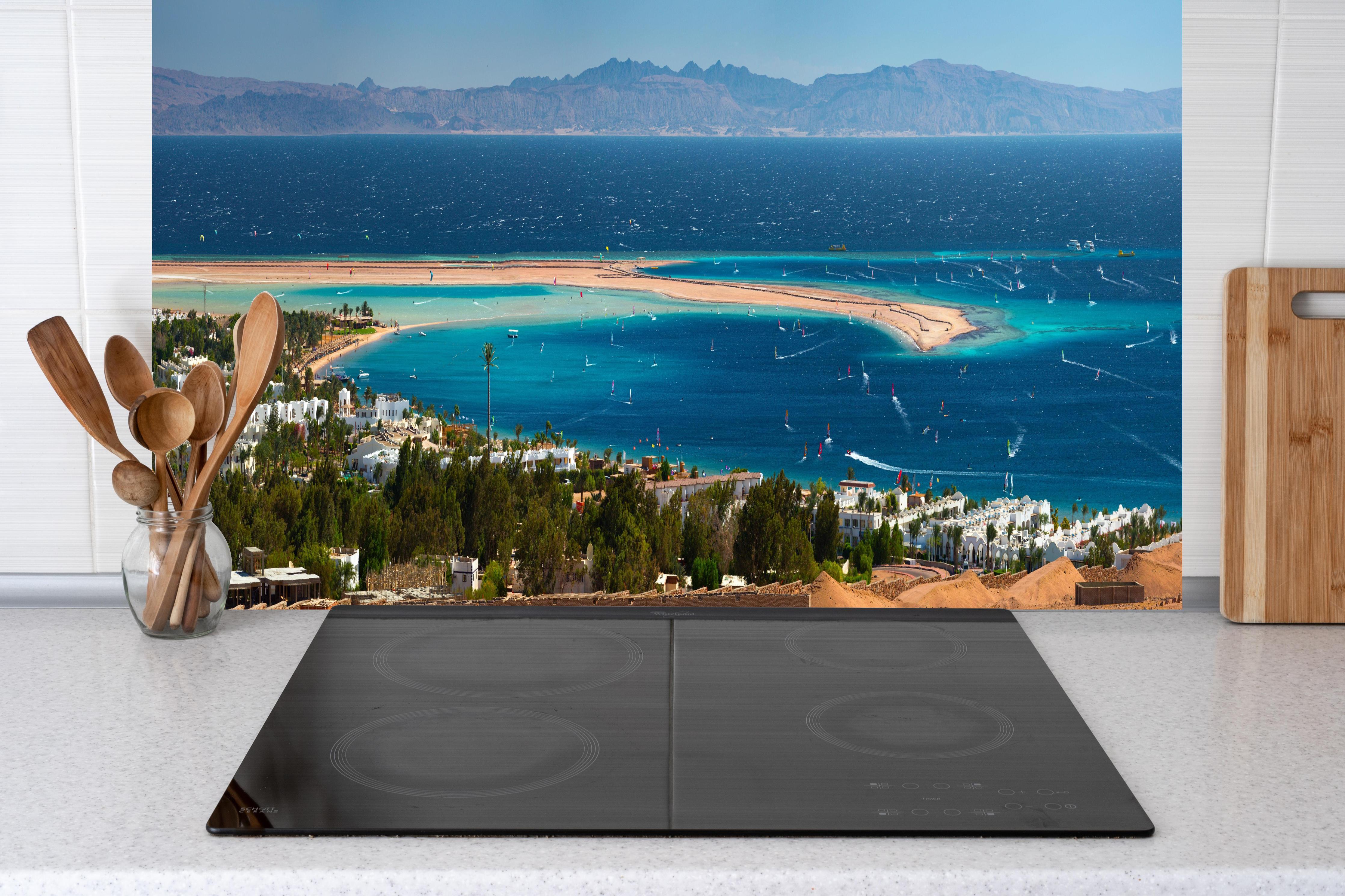 Küche - Blaue Lagune am Meer Panoramabild hinter weißen Hochglanz-Küchenregalen und schwarzem Wasserhahn