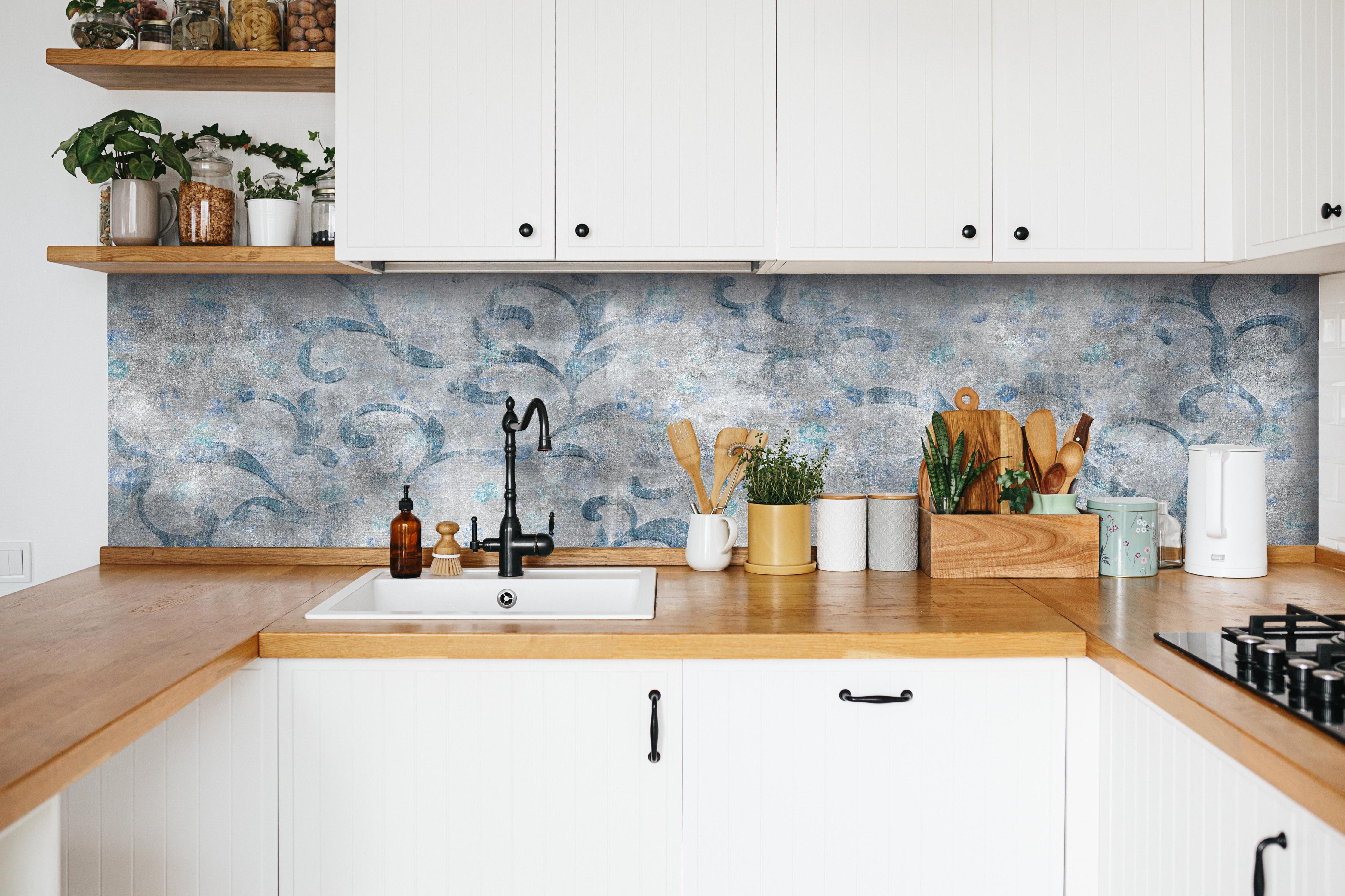 Küche - Blaues Blätter Muster - Zement hinter weißen Hochglanz-Küchenregalen und schwarzem Wasserhahn