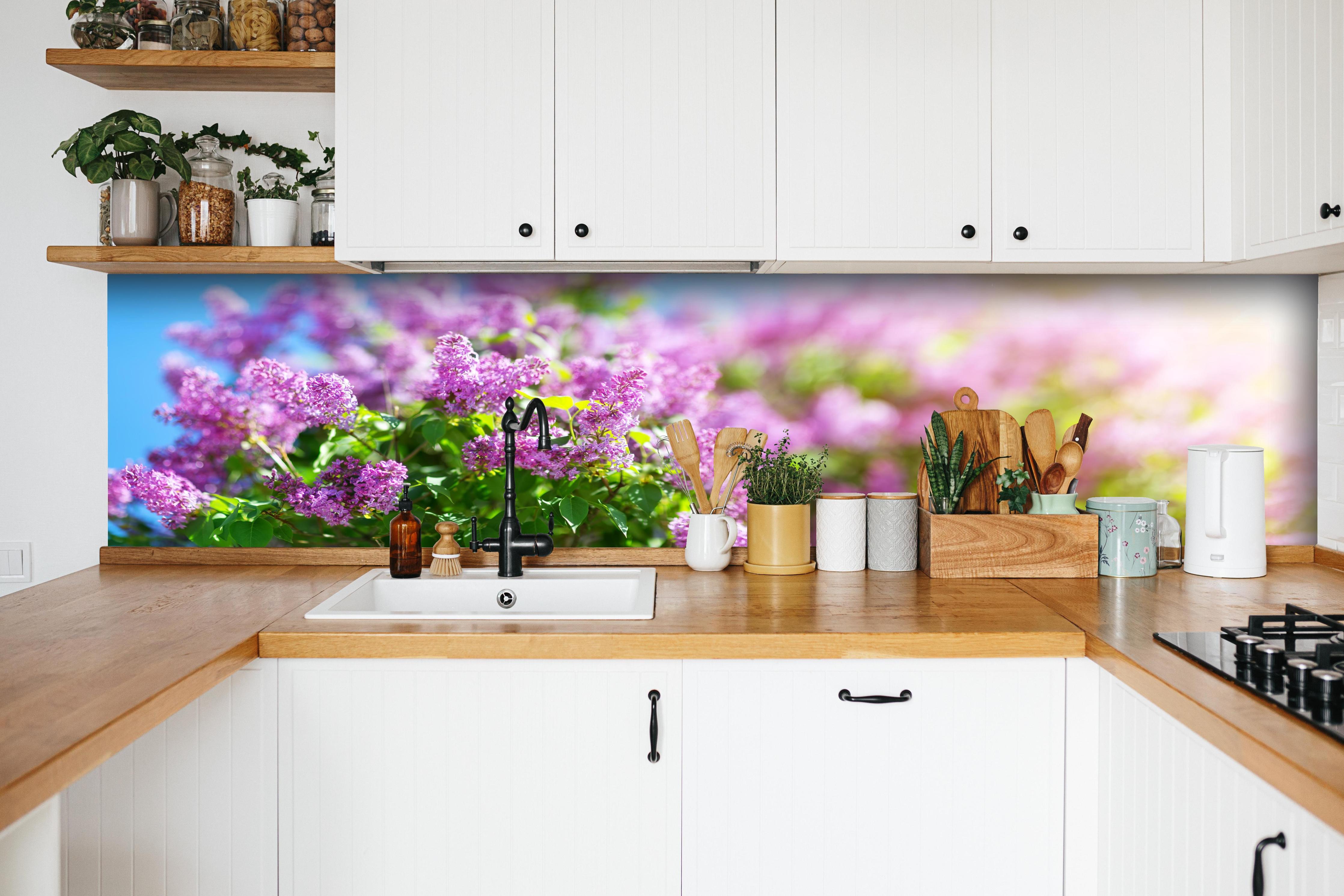 Küche - Blumen blühen auf im Frühling hinter weißen Hochglanz-Küchenregalen und schwarzem Wasserhahn