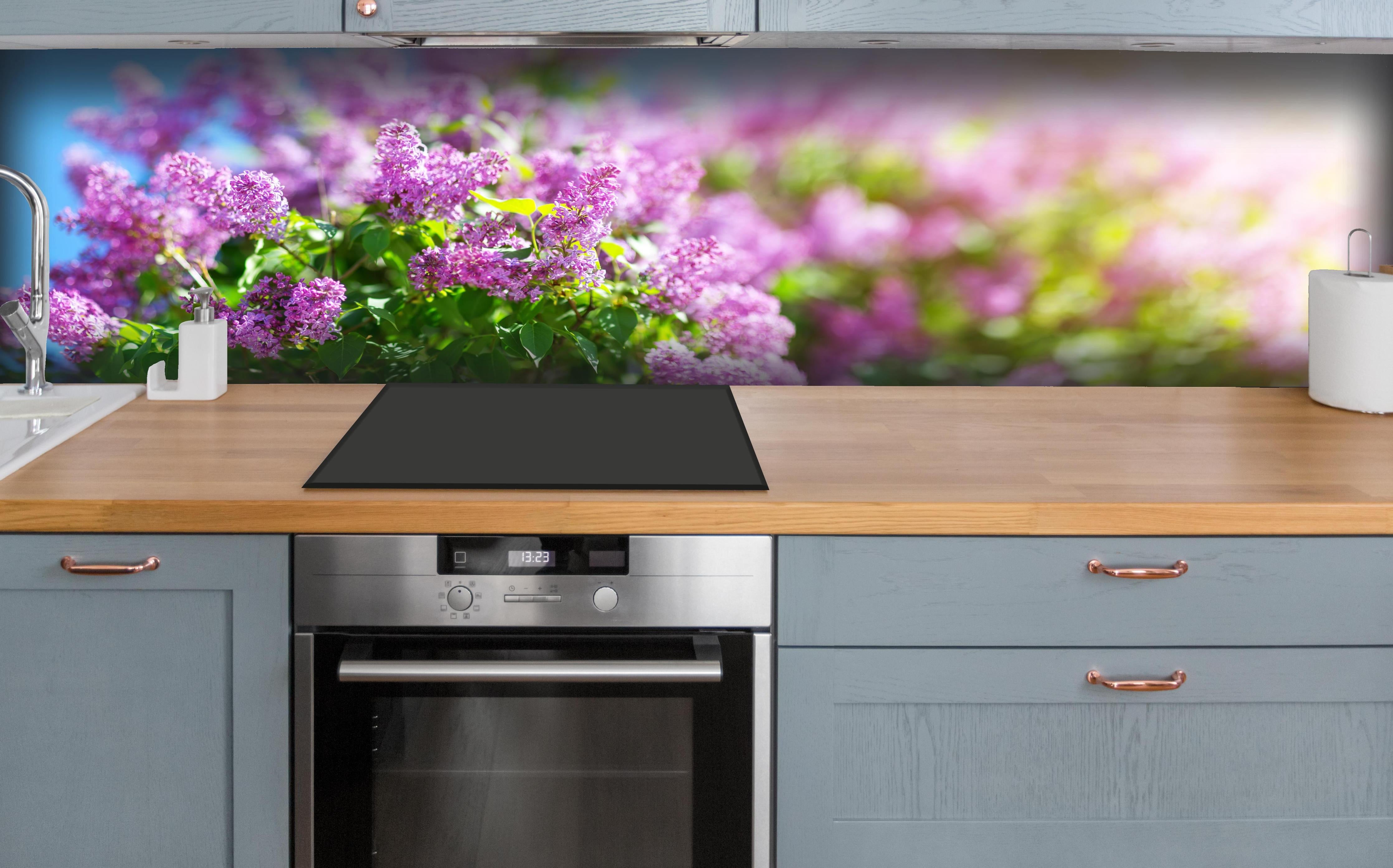 Küche - Blumen blühen auf im Frühling hinter weißen Hochglanz-Küchenregalen und schwarzem Wasserhahn