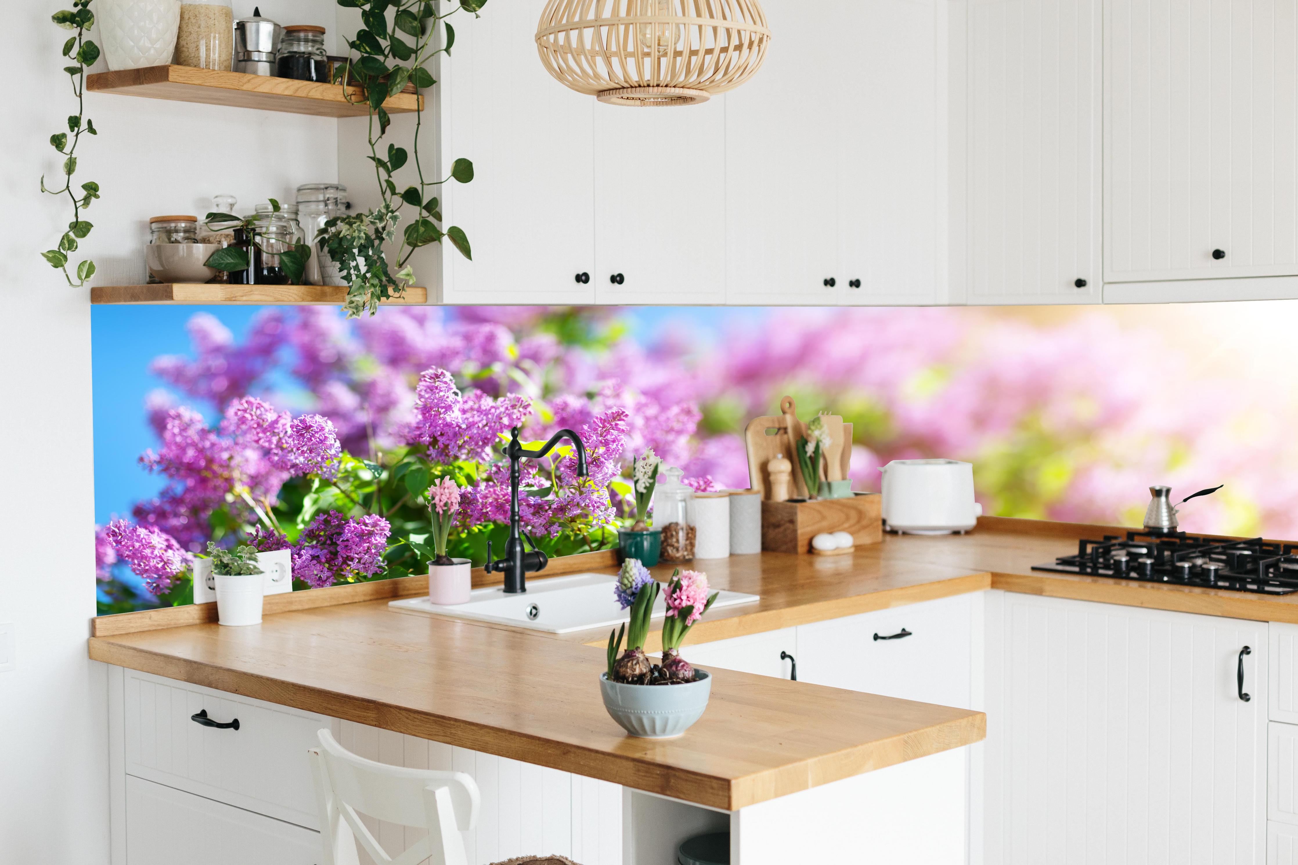 Küche - Blumen blühen auf im Frühling hinter weißen Hochglanz-Küchenregalen und schwarzem Wasserhahn