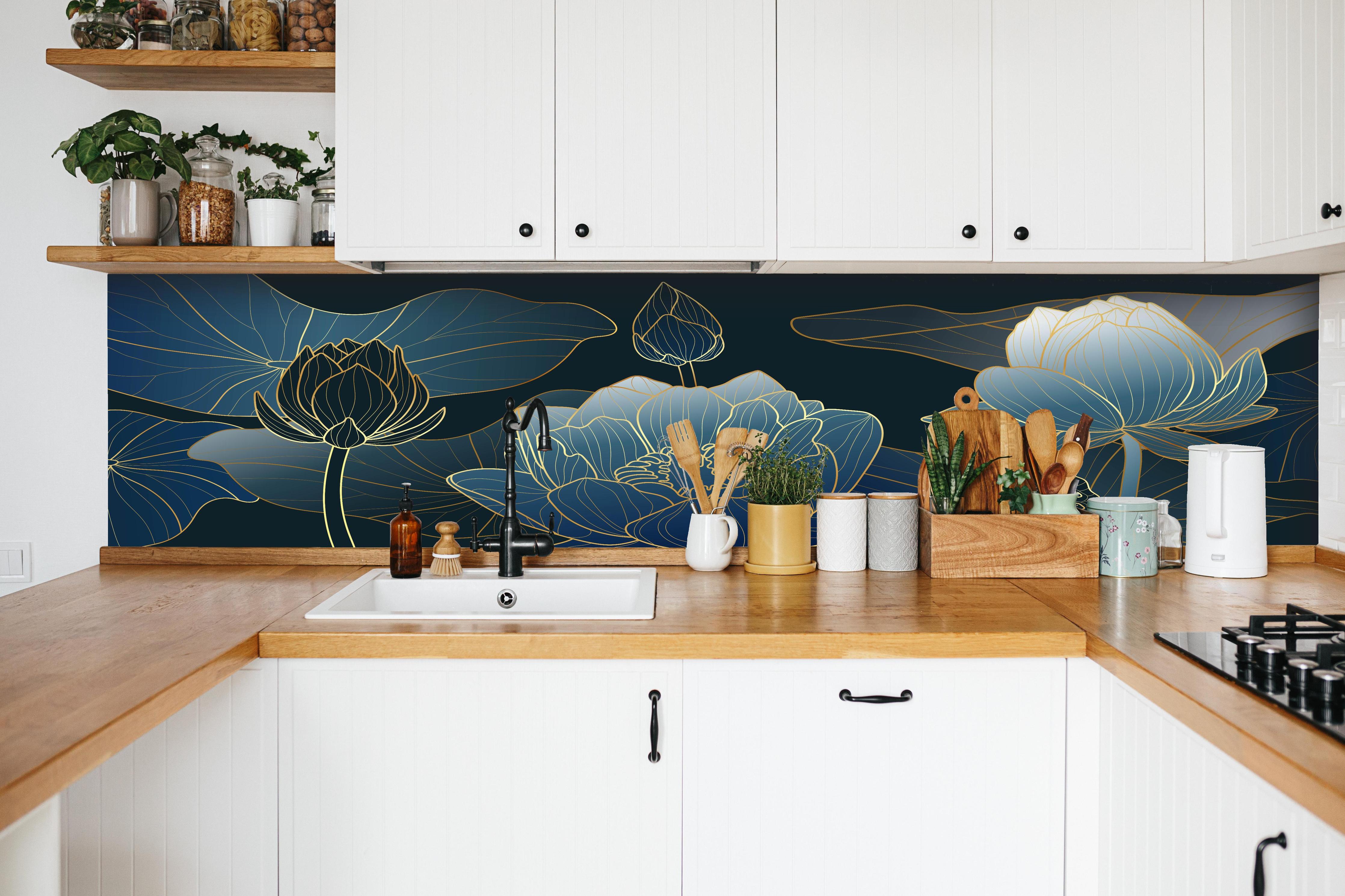 Küche - Blumendesign in Blau-Weiß mit goldenen Akzenten hinter weißen Hochglanz-Küchenregalen und schwarzem Wasserhahn