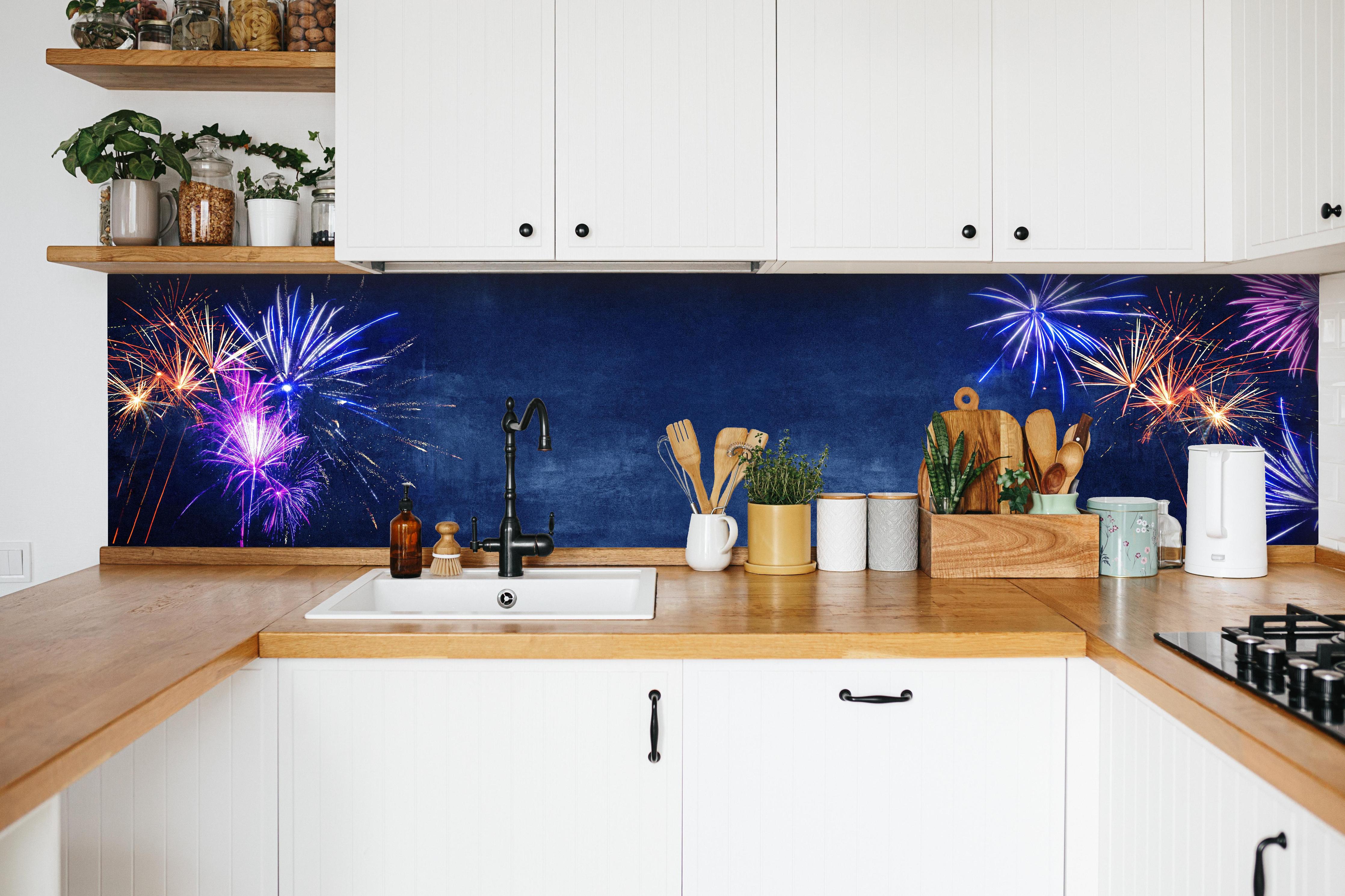 Küche - Buntes Silvester-Feuerwerk am Dunkelblauen Himmel hinter weißen Hochglanz-Küchenregalen und schwarzem Wasserhahn