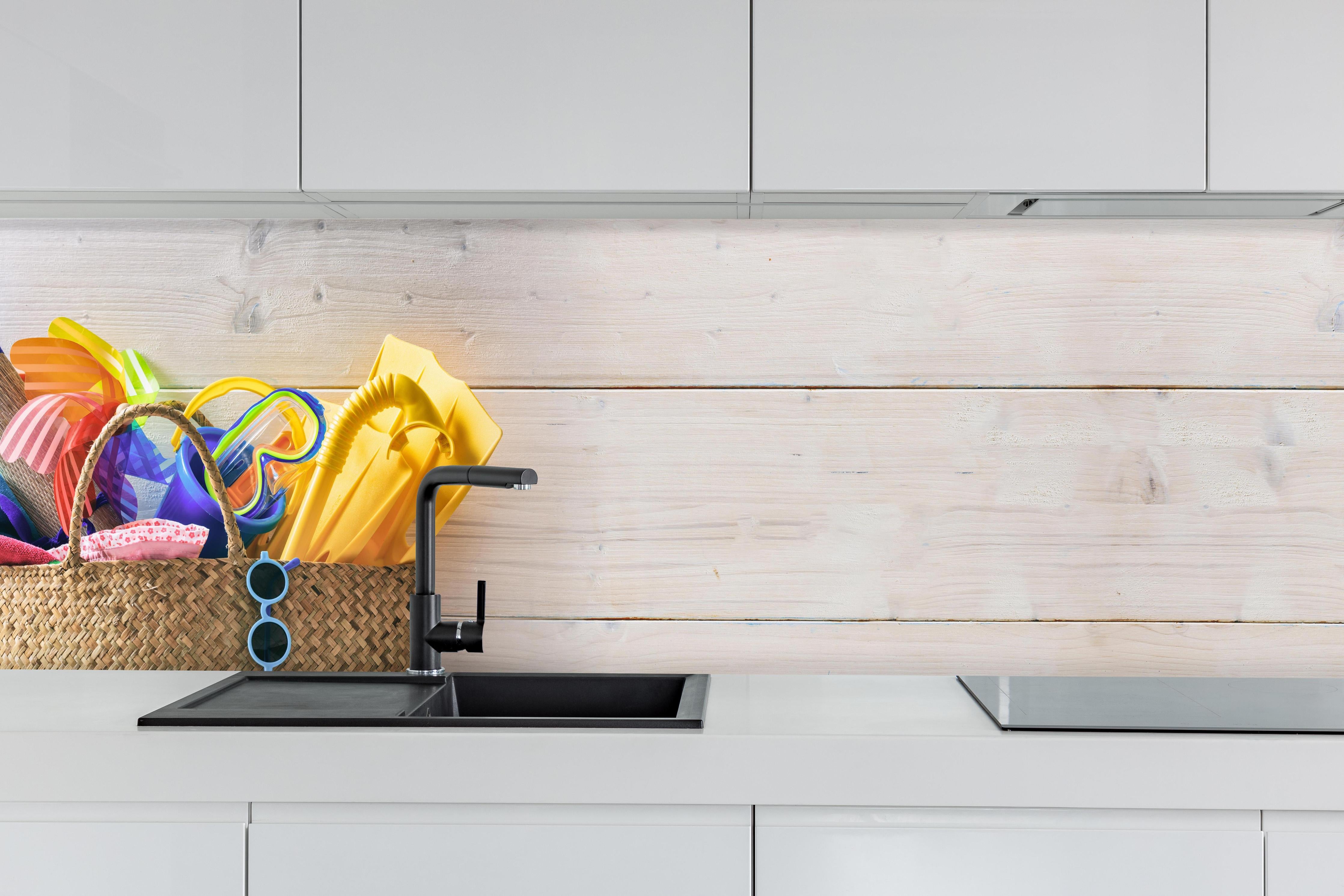 Küche - Buntes Sommer, Strand & Meer Zubehör hinter weißen Hochglanz-Küchenregalen und schwarzem Wasserhahn