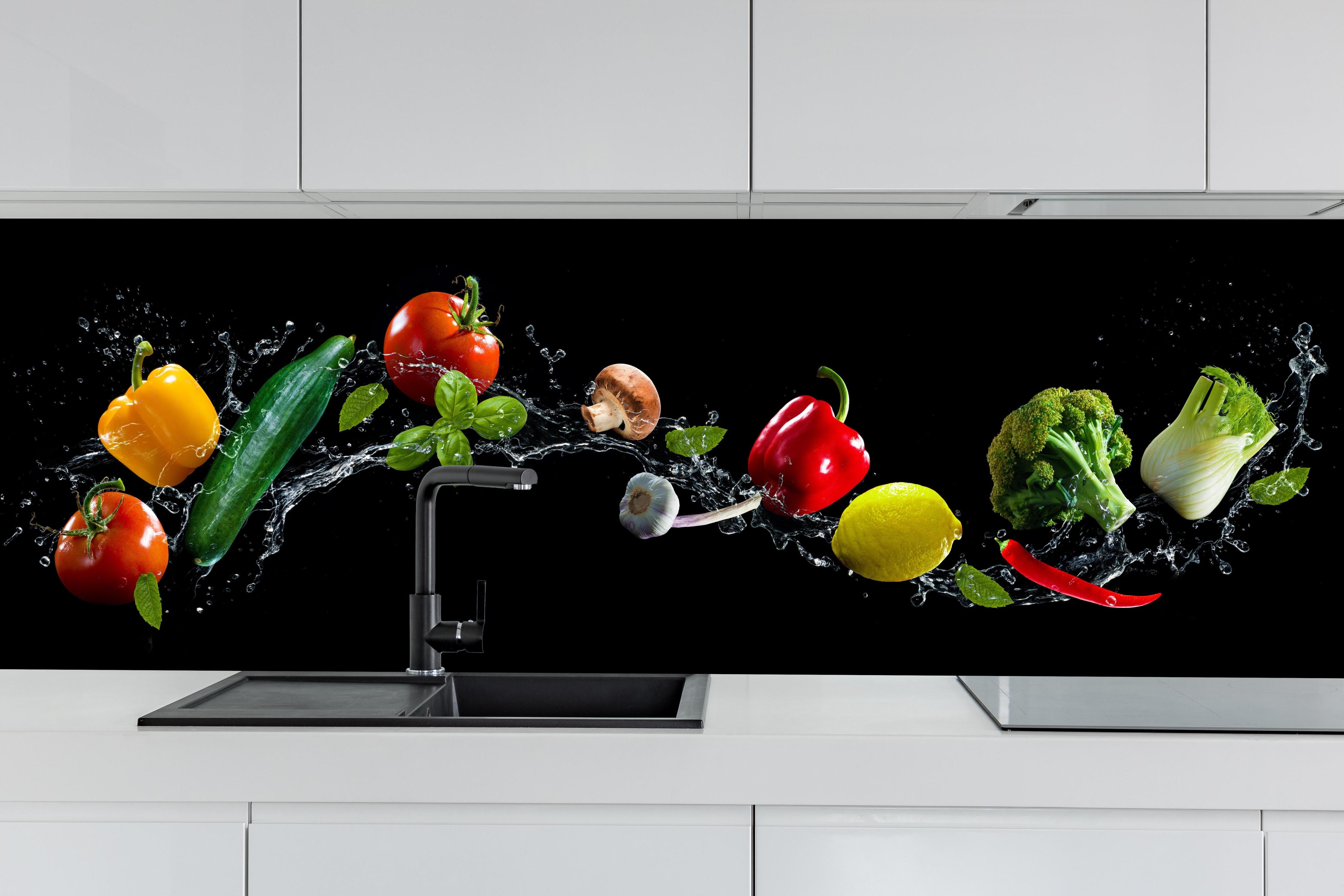 Küche - Buntes Spritzwasser-Gemüse auf Schwarz hinter weißen Hochglanz-Küchenregalen und schwarzem Wasserhahn