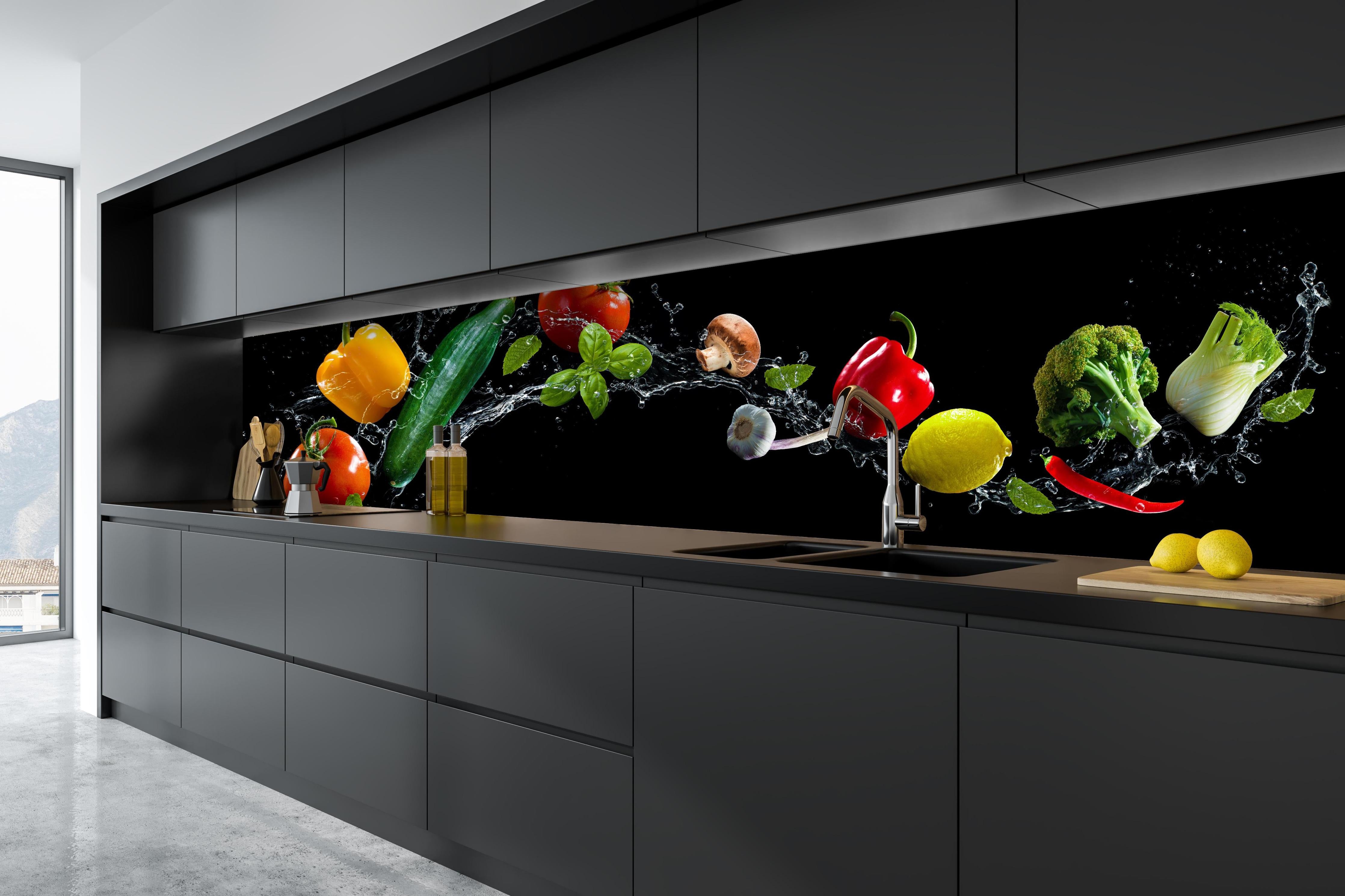 Küche - Buntes Spritzwasser-Gemüse auf Schwarz hinter weißen Hochglanz-Küchenregalen und schwarzem Wasserhahn