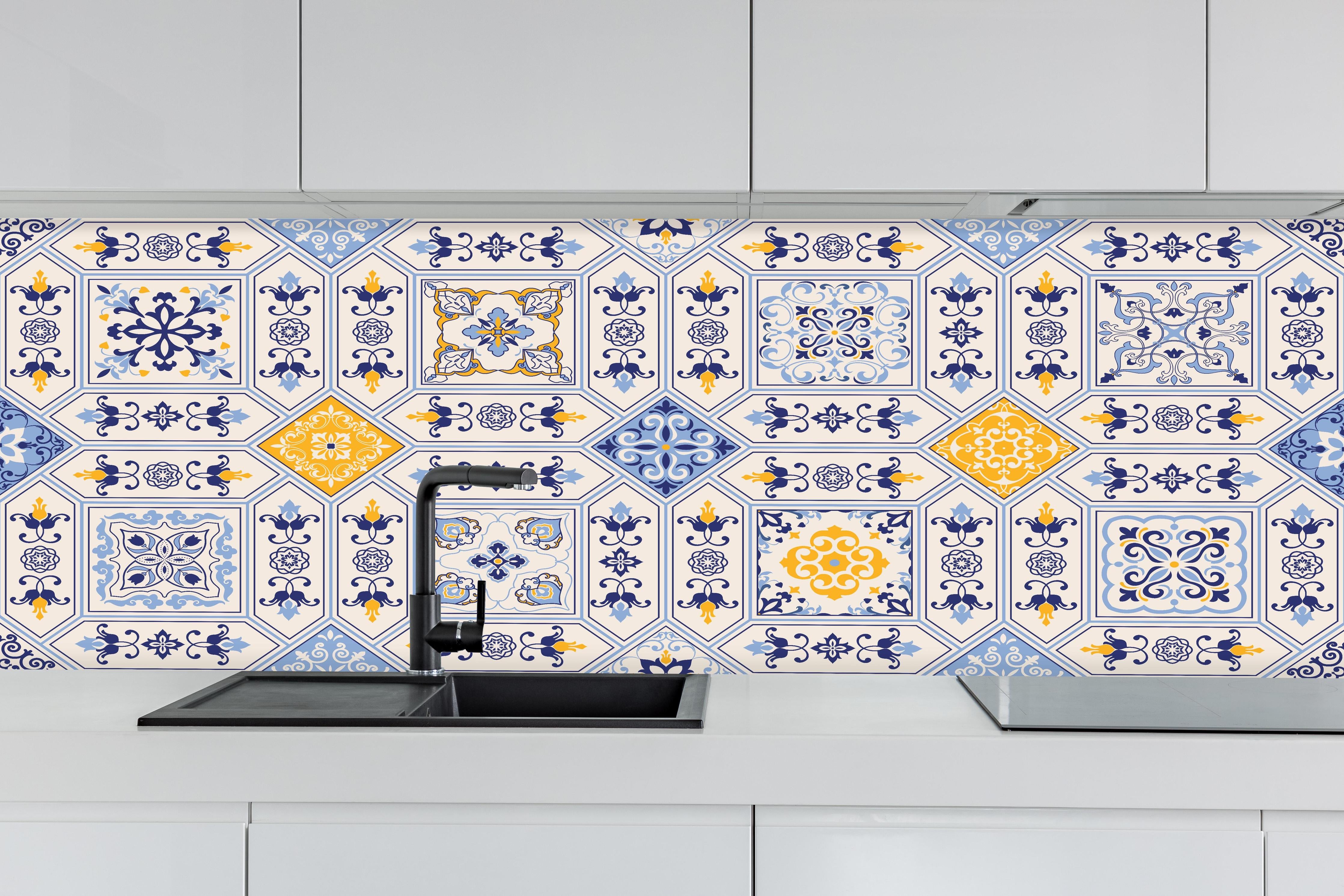 Küche - Dekorative Blau-Gelbe Keramikfliesen hinter weißen Hochglanz-Küchenregalen und schwarzem Wasserhahn