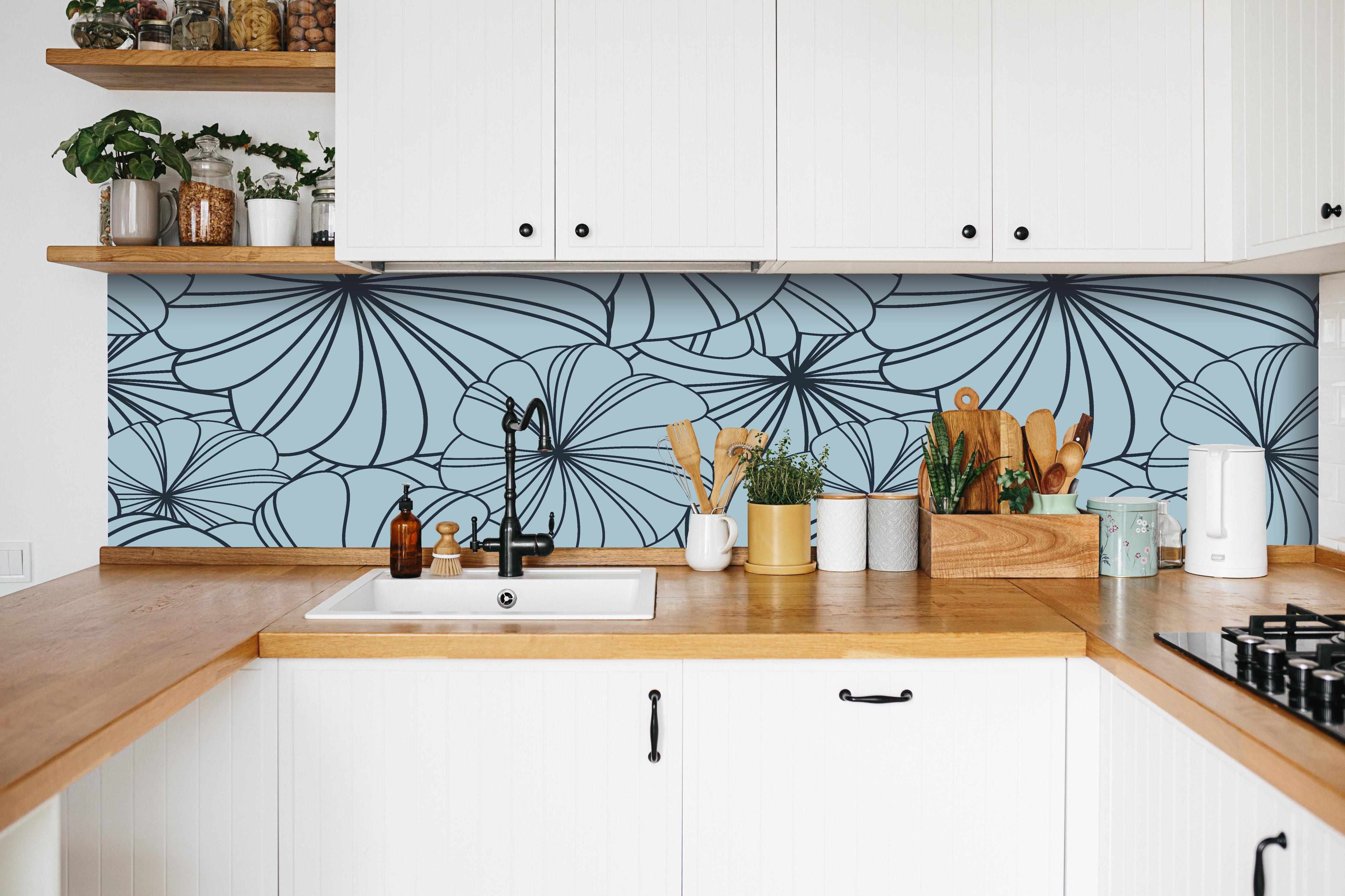 Küche - Dekoratives Blumenmuster in Blautönen hinter weißen Hochglanz-Küchenregalen und schwarzem Wasserhahn