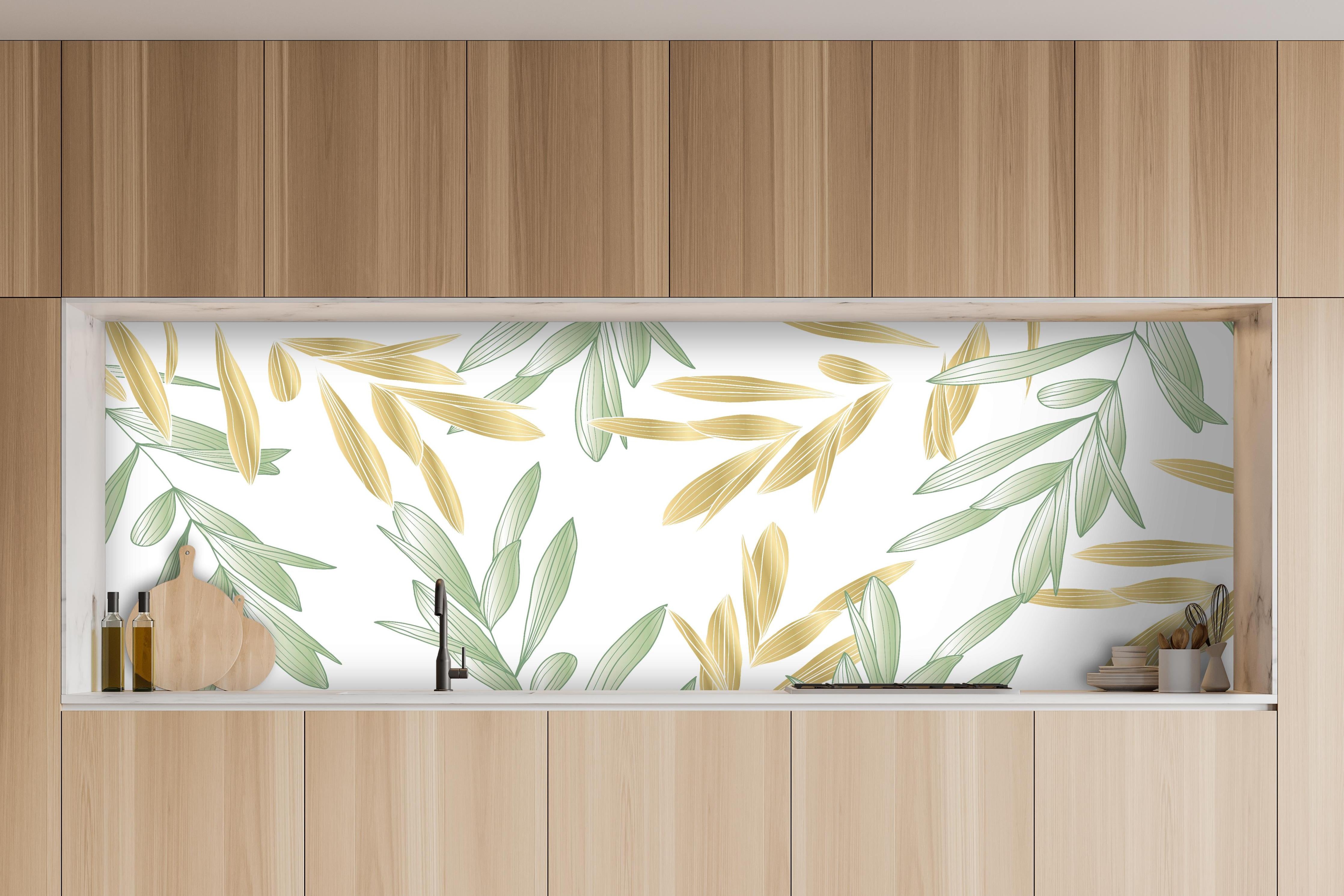 Küche - Dekoratives Grün-Gold Pflanzen-Design hinter weißen Hochglanz-Küchenregalen und schwarzem Wasserhahn