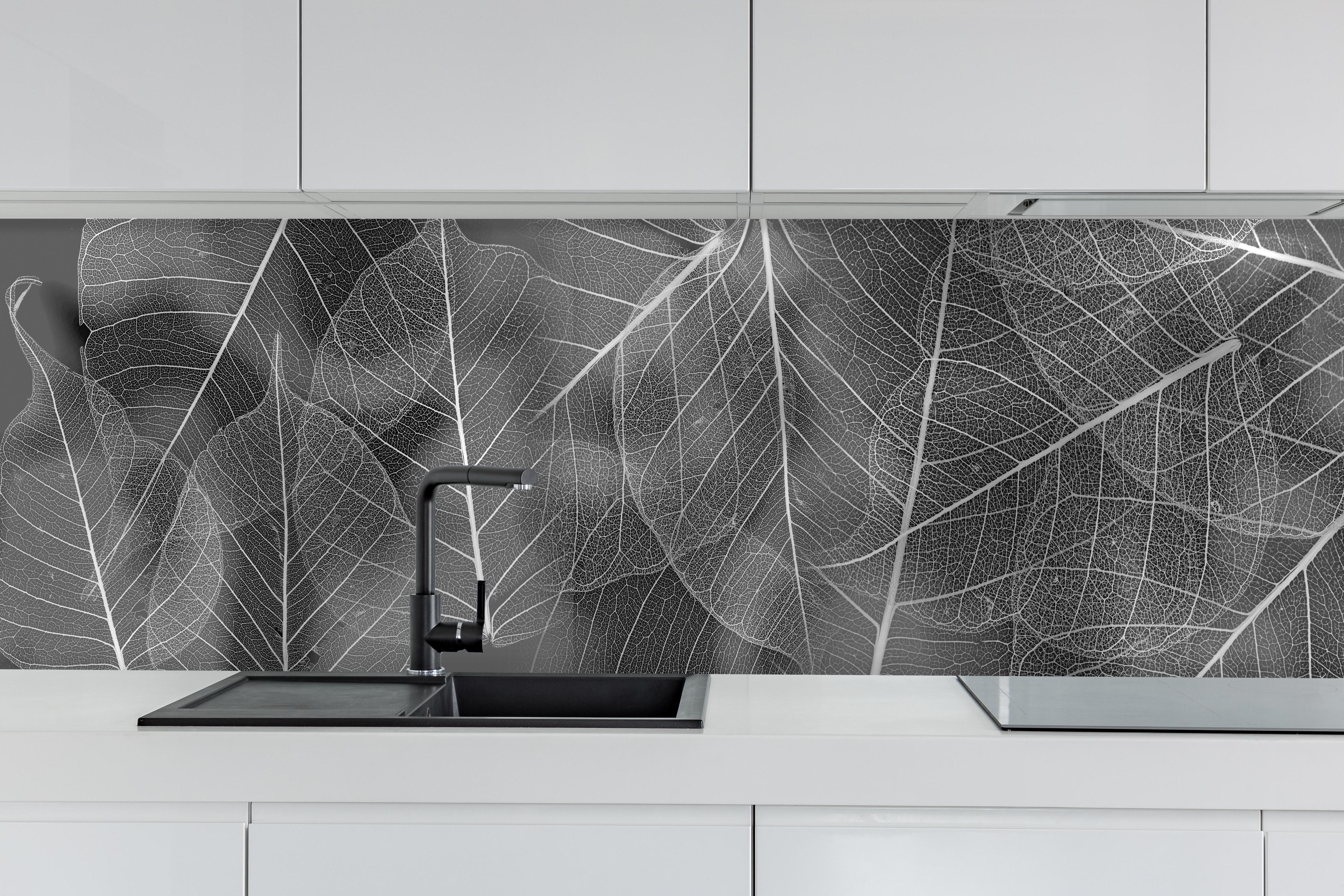 Küche - Detailreiche Grau-Weiße Blattstruktur Makro hinter weißen Hochglanz-Küchenregalen und schwarzem Wasserhahn
