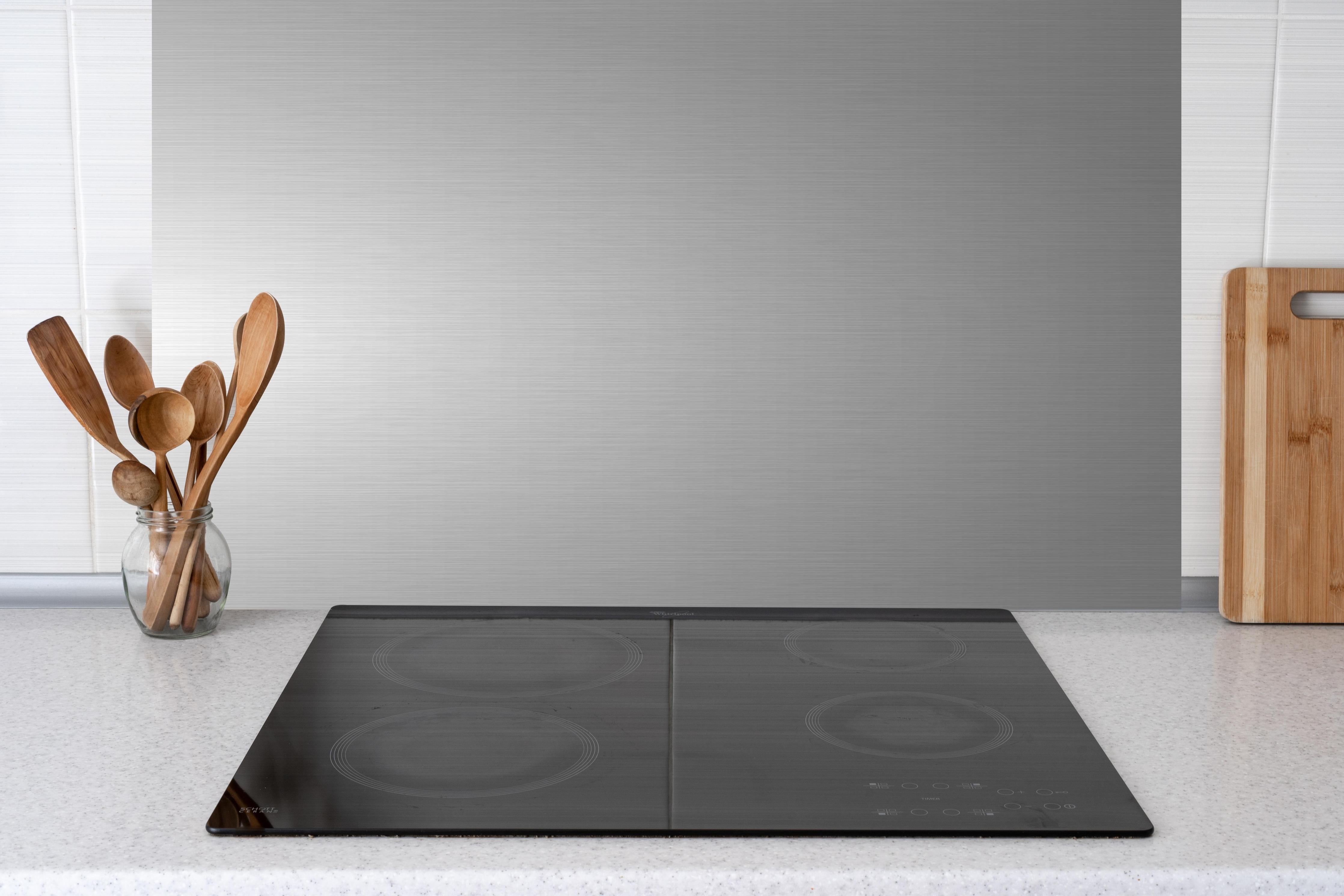 Küche - Edler gebürsteter Metall-Hintergrund in Graunuancen hinter weißen Hochglanz-Küchenregalen und schwarzem Wasserhahn