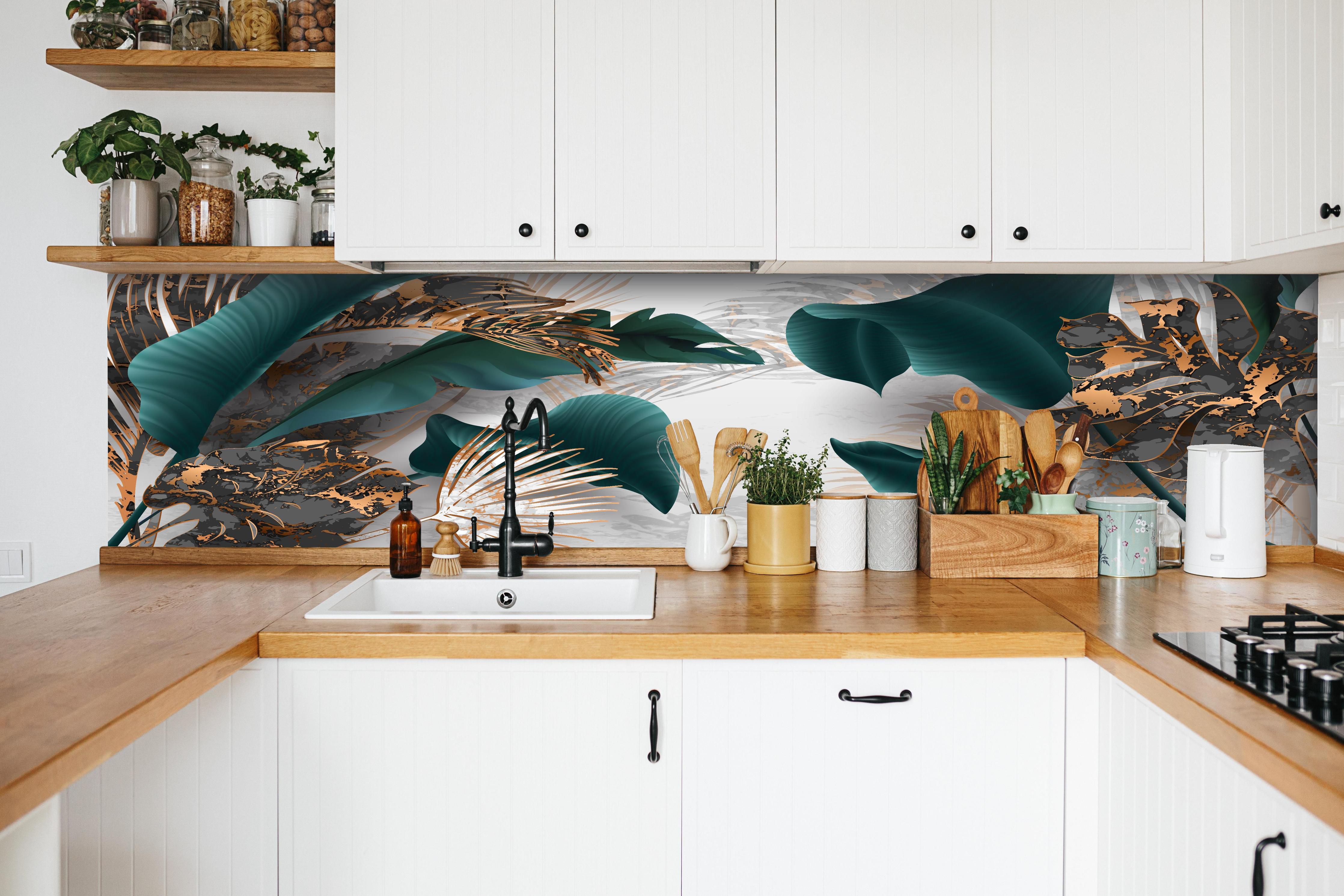 Küche - Edles Blattwerk in Grün mit Goldakzenten hinter weißen Hochglanz-Küchenregalen und schwarzem Wasserhahn