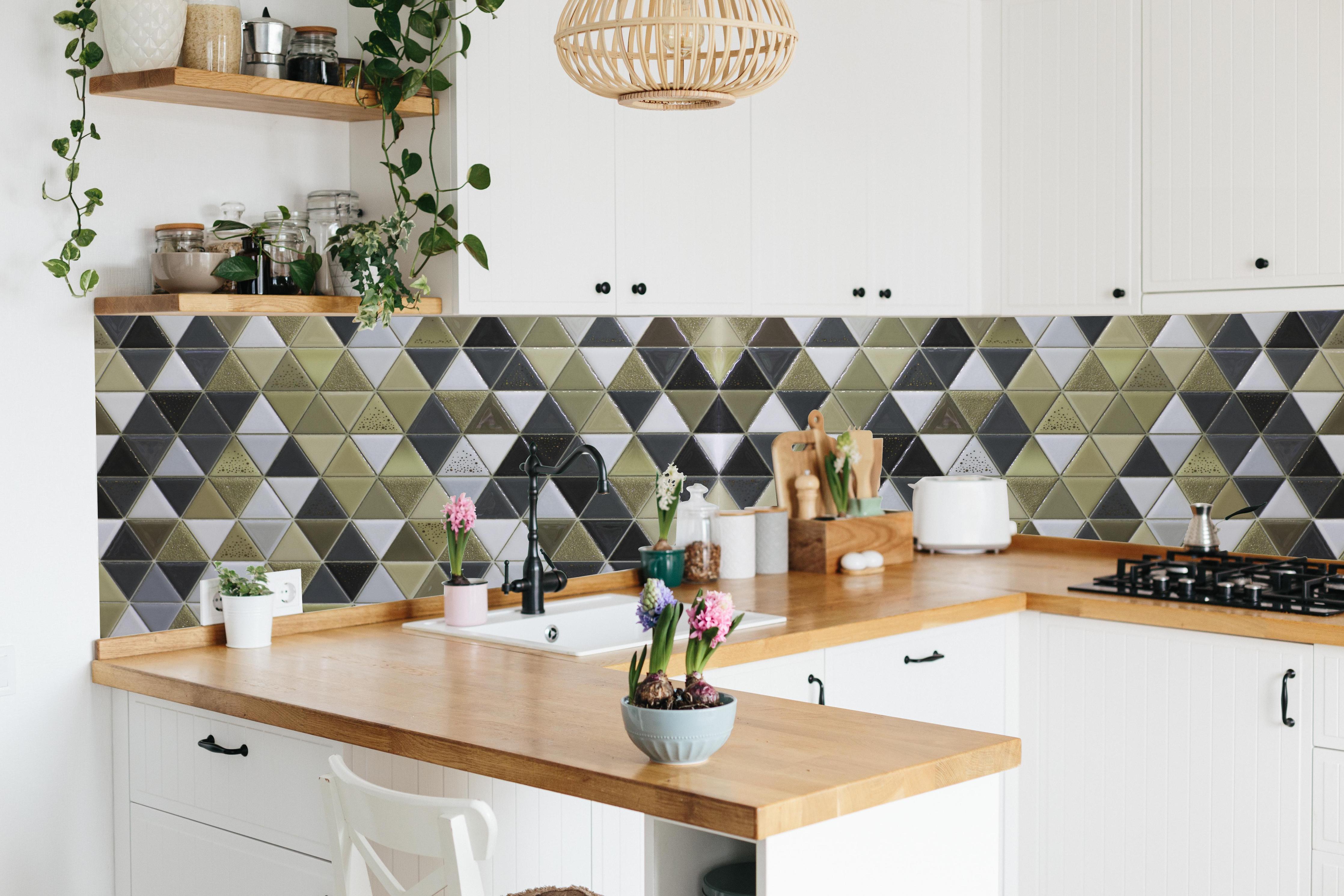 Küche - Edles Fliesen-Dekor in Schwarz, Weiß und Gold hinter weißen Hochglanz-Küchenregalen und schwarzem Wasserhahn