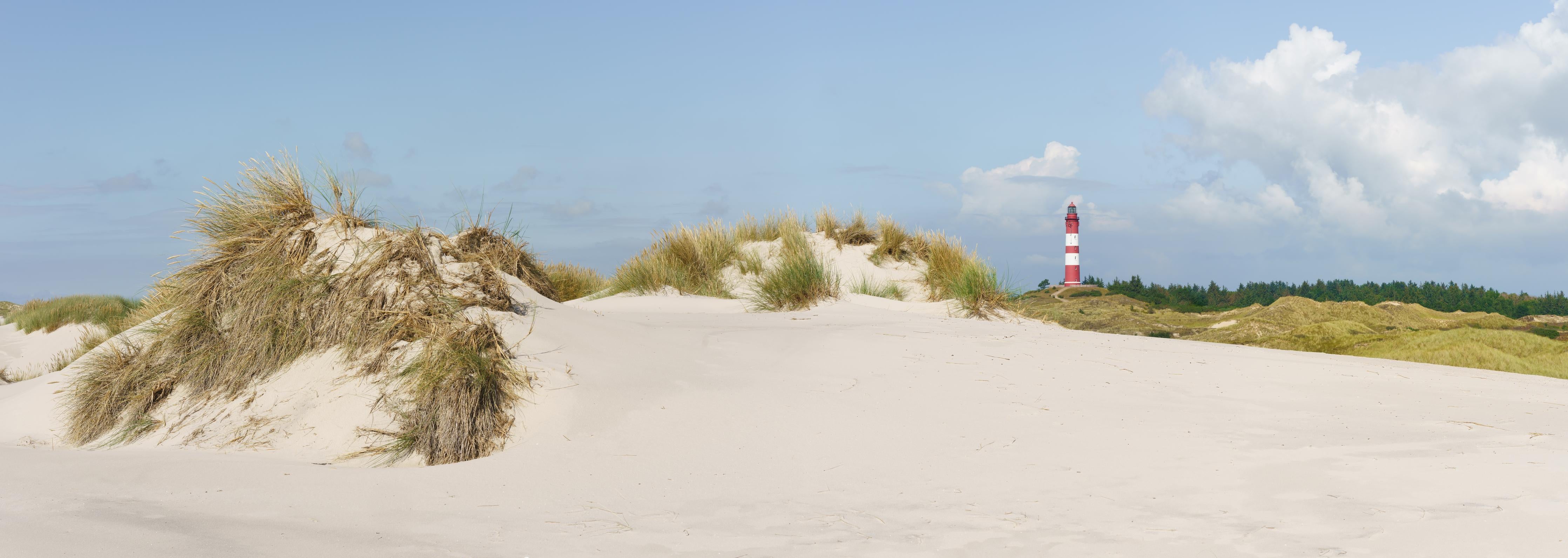 Küchenrückwand-Ein traumhafter Blick auf die weiße Sanddüne und den roten Leuchtturm am Meer