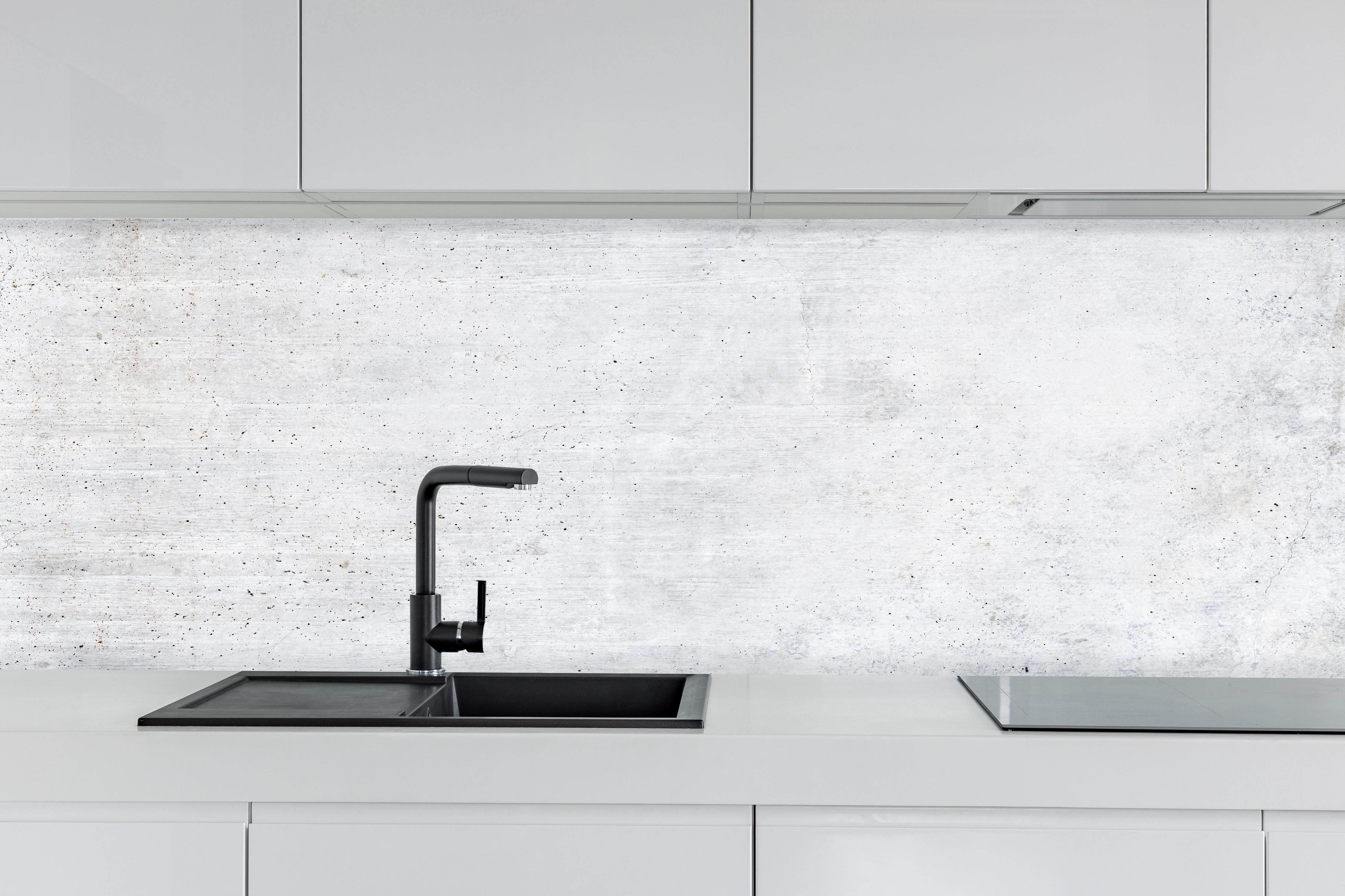 Küche - Einfache Textur einer weißen Wand hinter weißen Hochglanz-Küchenregalen und schwarzem Wasserhahn