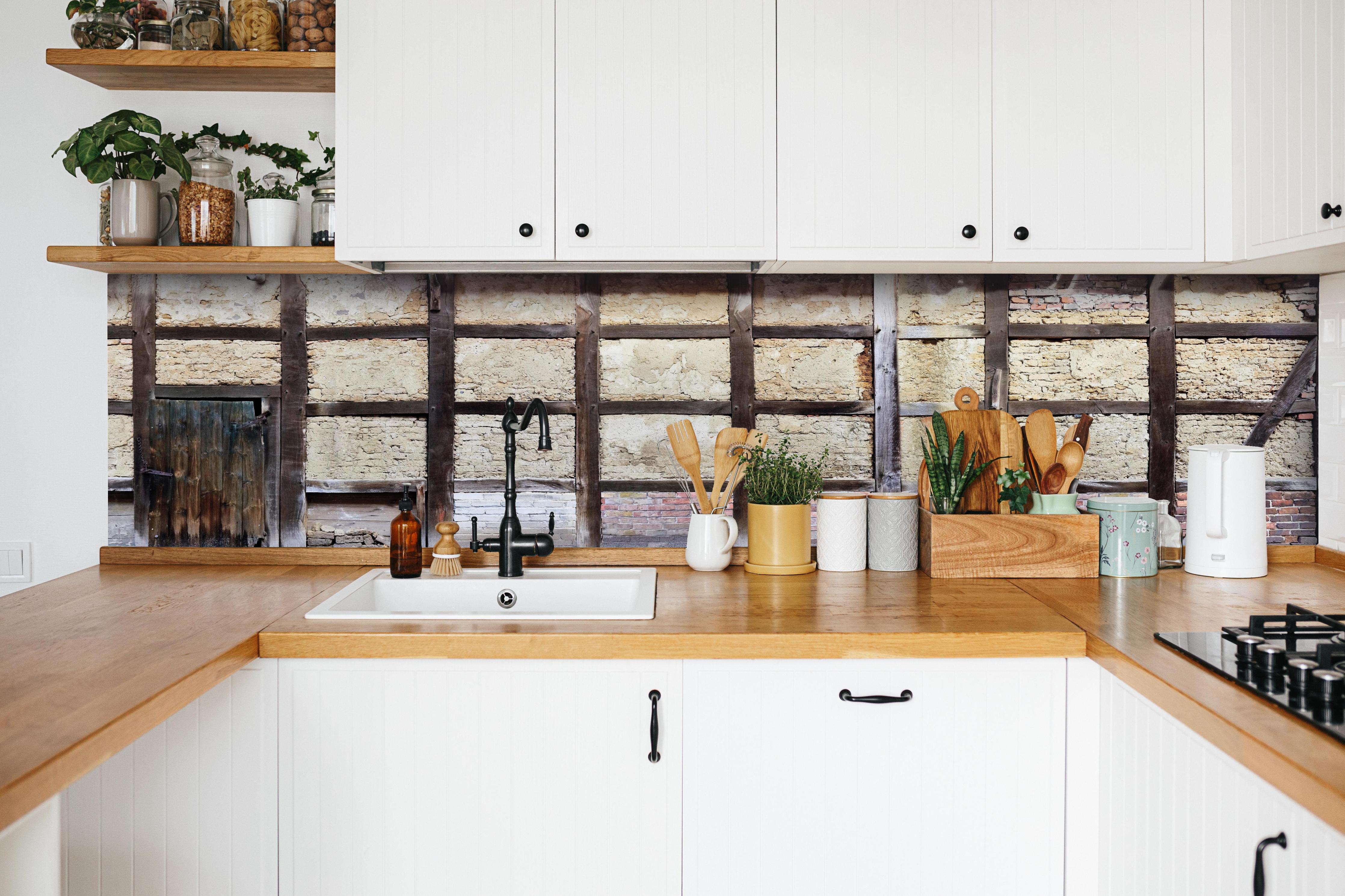 Küche - Eingang eines Deutschen Fachwerkhauses hinter weißen Hochglanz-Küchenregalen und schwarzem Wasserhahn