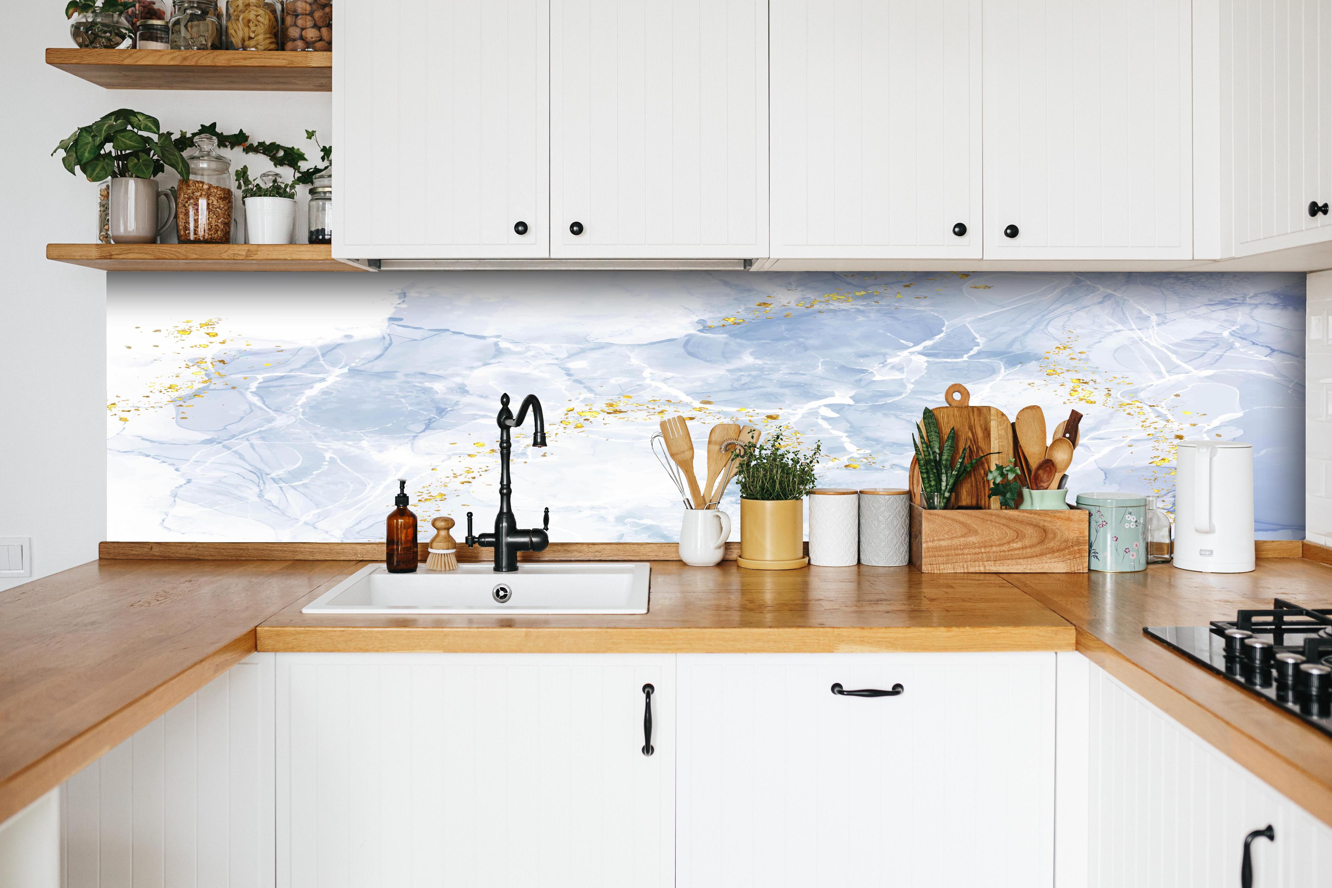 Küche - Eisiges Blau mit Goldakzenten hinter weißen Hochglanz-Küchenregalen und schwarzem Wasserhahn