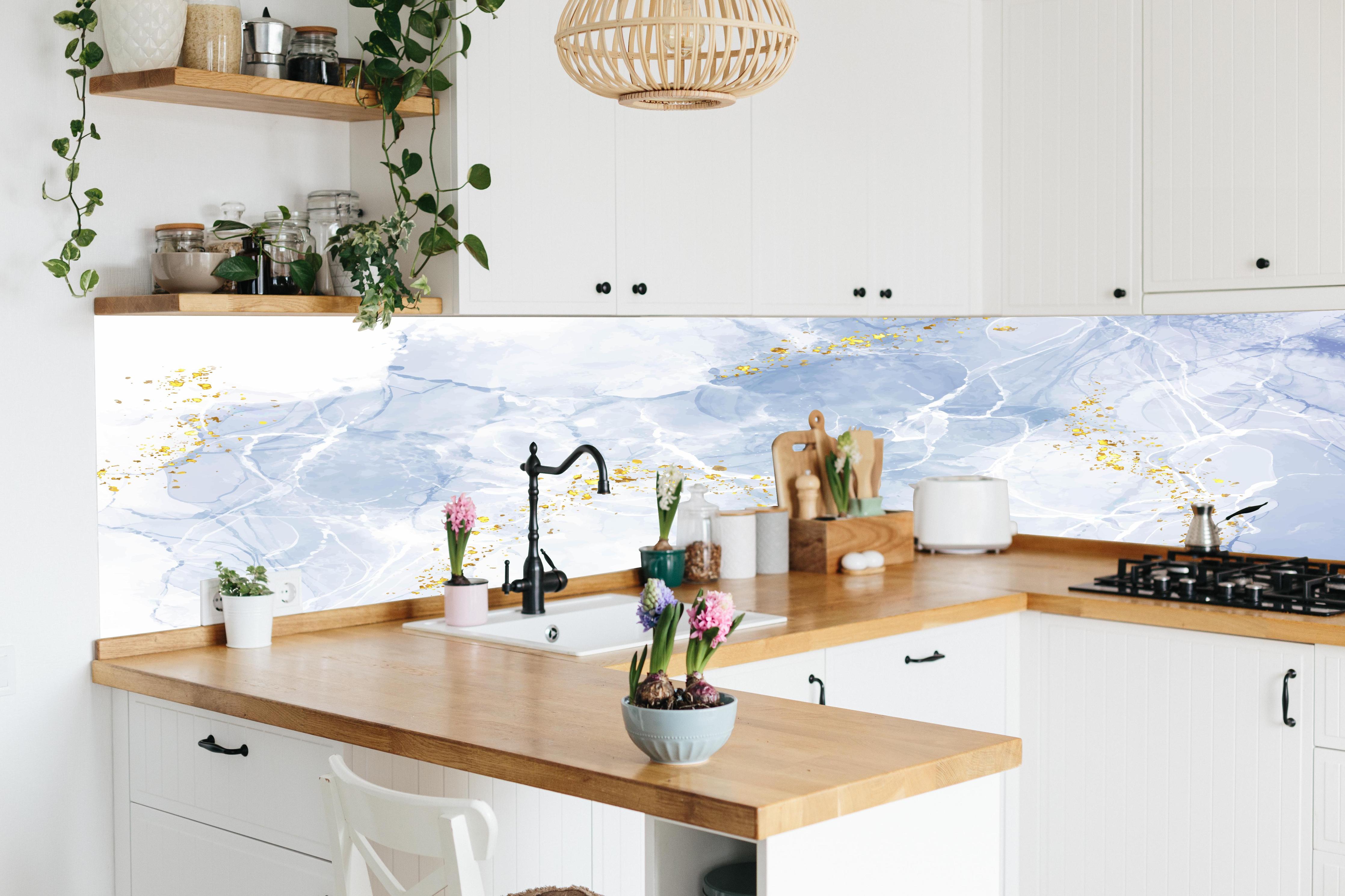 Küche - Eisiges Blau mit Goldakzenten hinter weißen Hochglanz-Küchenregalen und schwarzem Wasserhahn