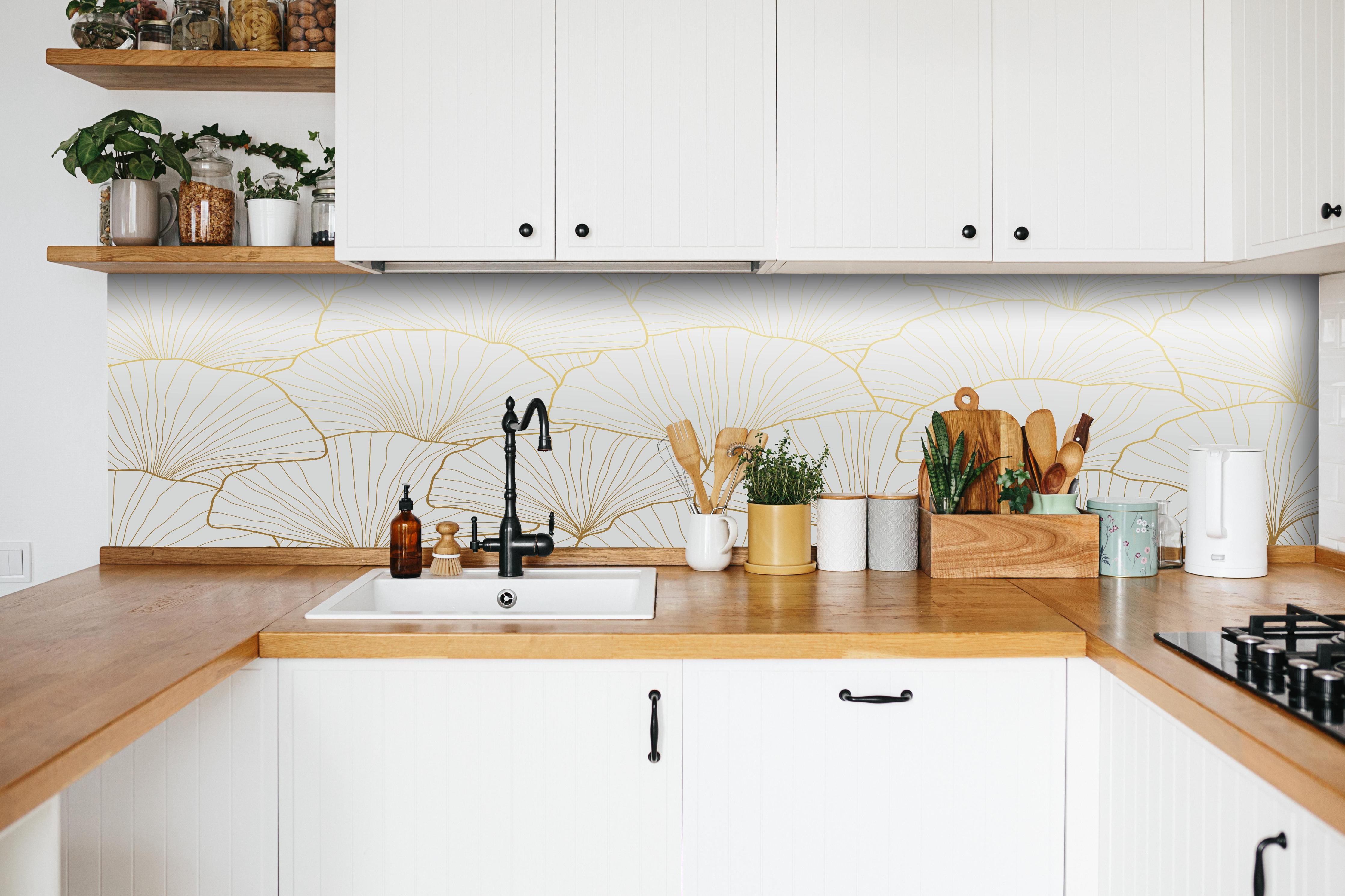 Küche - Elegante Ginkgo Tapete in Blattgold-Optik hinter weißen Hochglanz-Küchenregalen und schwarzem Wasserhahn