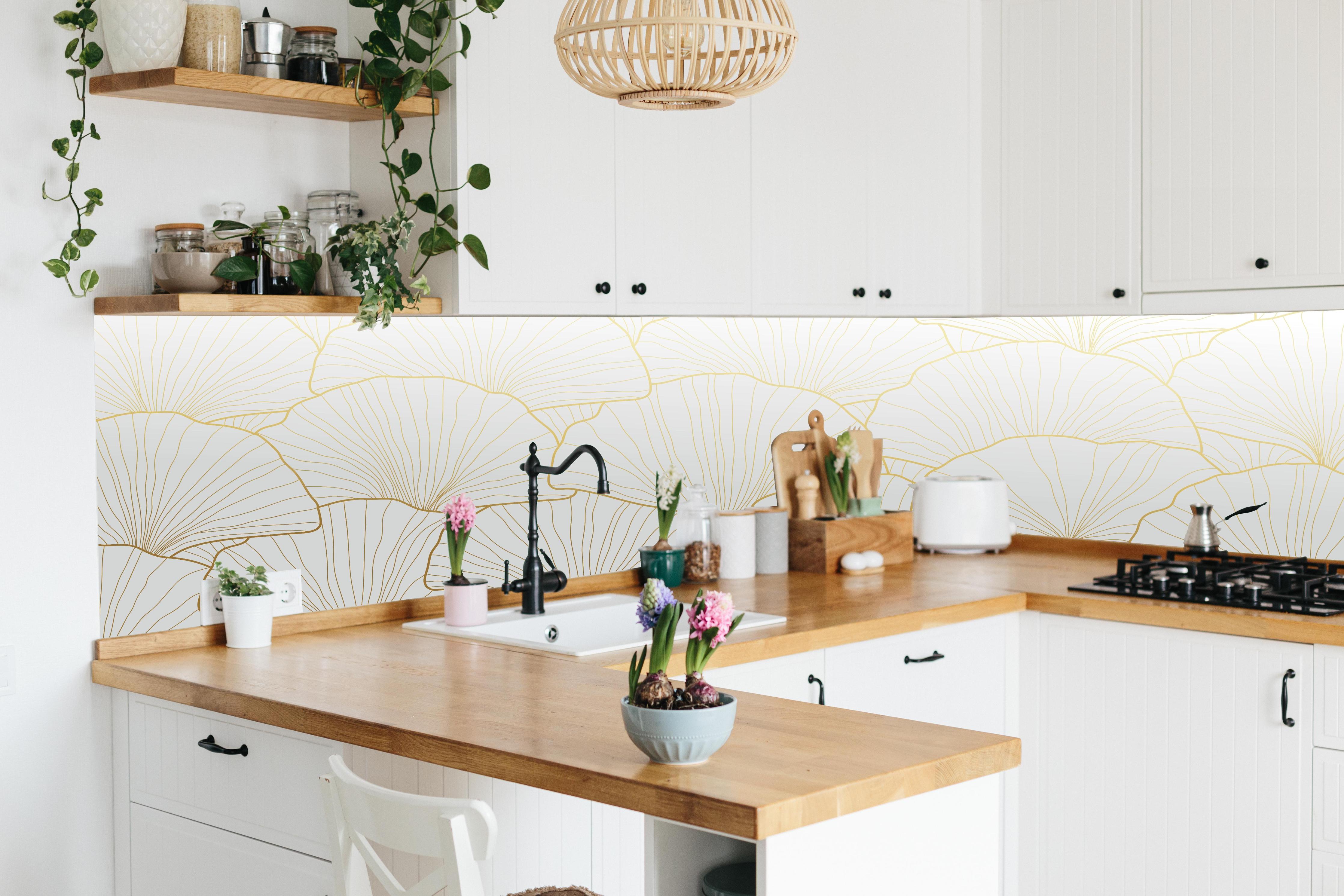 Küche - Elegante Ginkgo Tapete in Blattgold-Optik hinter weißen Hochglanz-Küchenregalen und schwarzem Wasserhahn