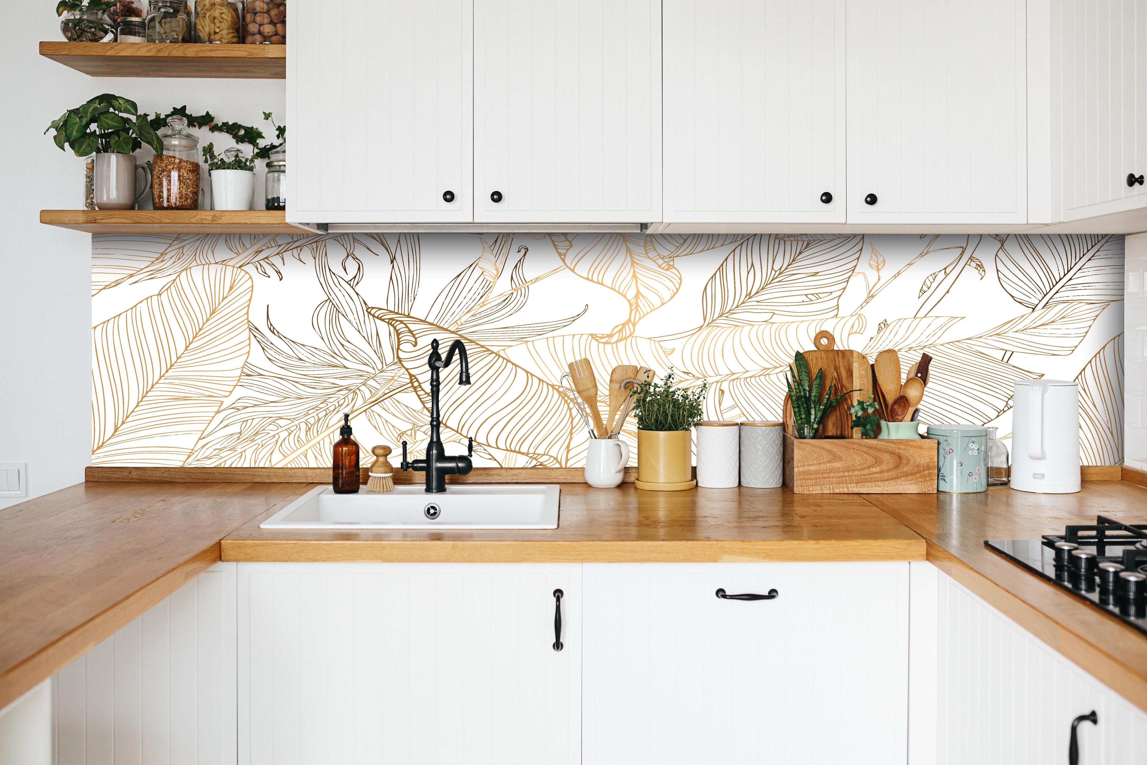 Küche - Elegante Goldene Linien Kunst Pflanzenmuster hinter weißen Hochglanz-Küchenregalen und schwarzem Wasserhahn