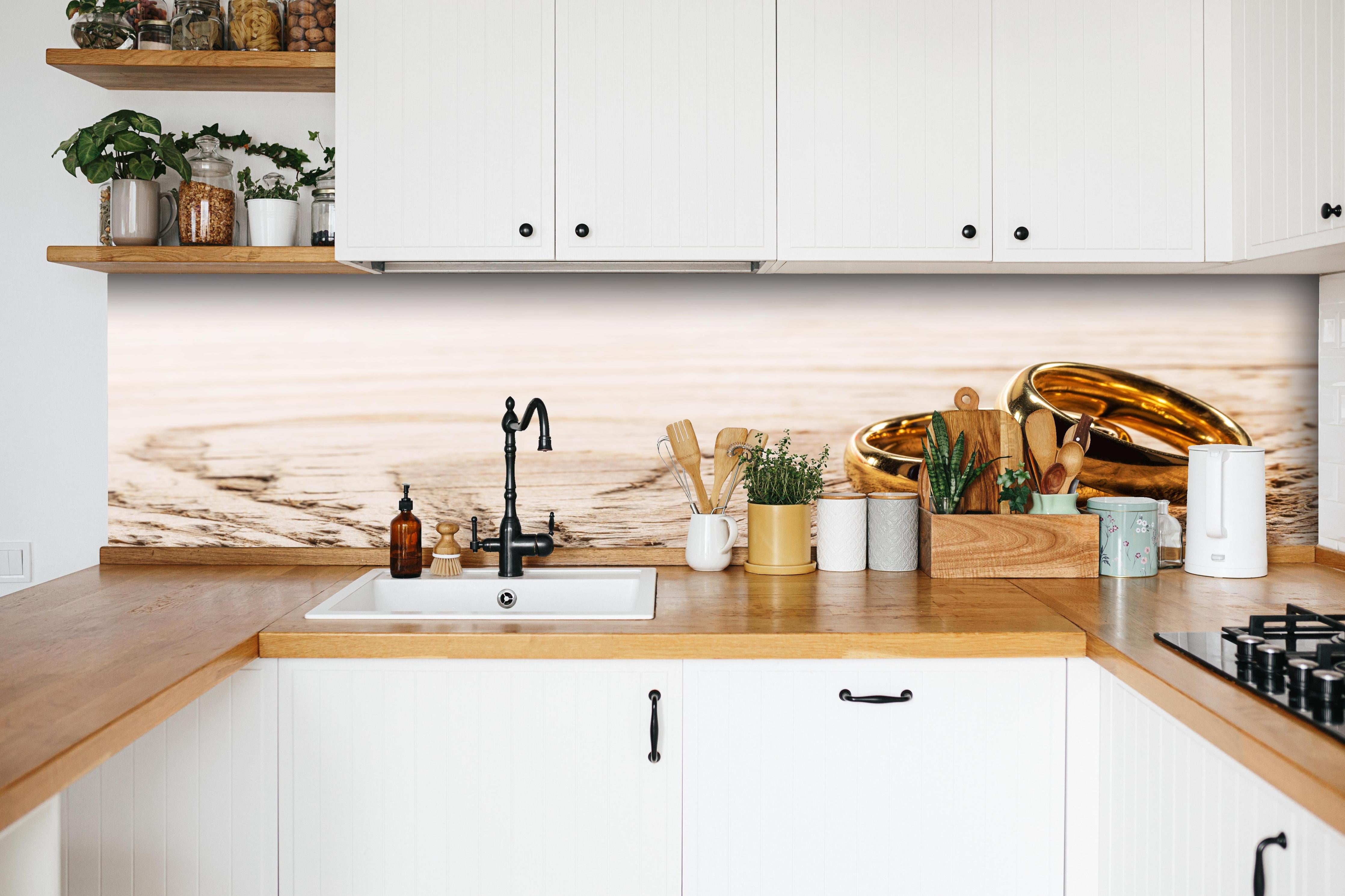 Küche - Elegante Goldringe auf rustikalem Holz hinter weißen Hochglanz-Küchenregalen und schwarzem Wasserhahn