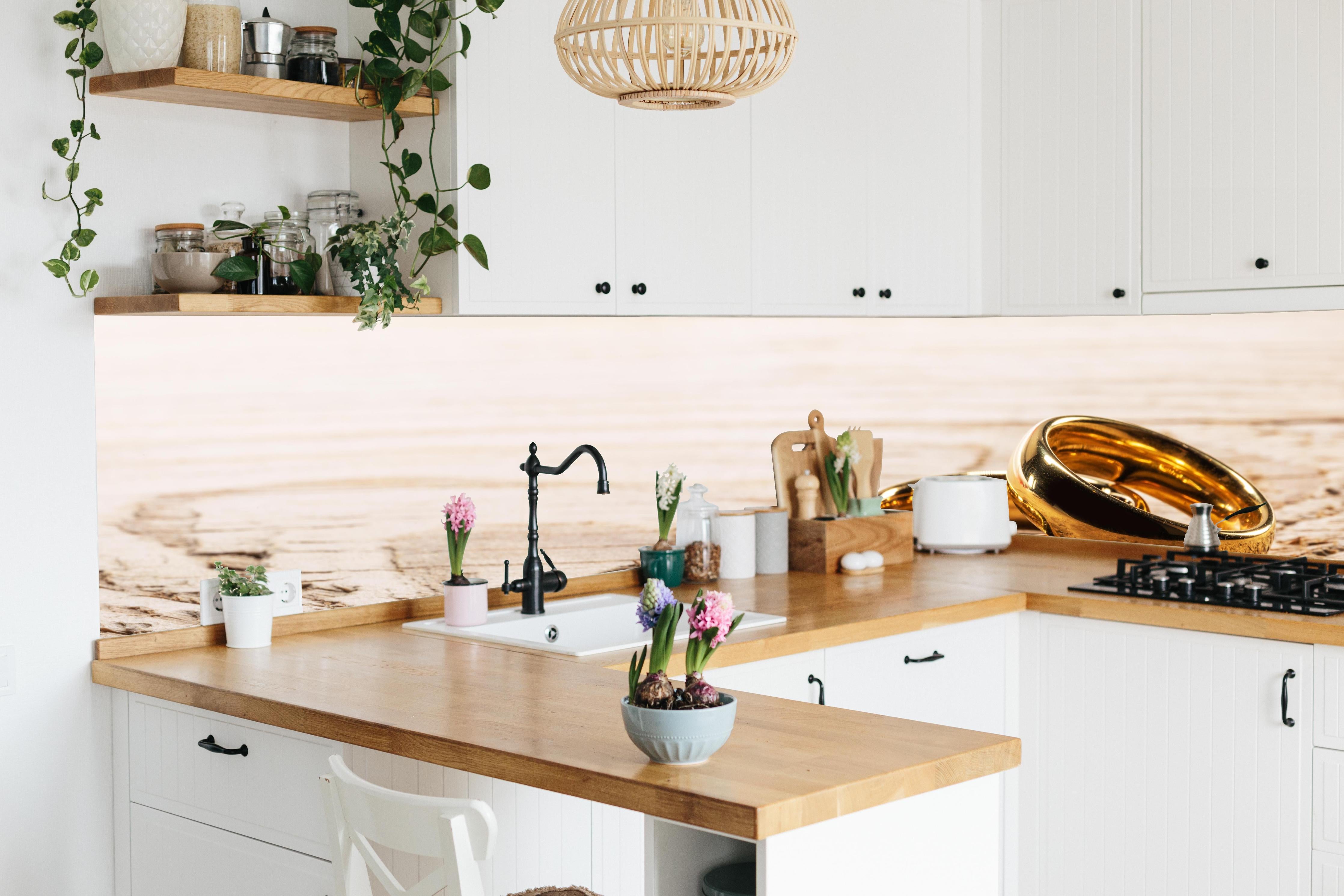 Küche - Elegante Goldringe auf rustikalem Holz hinter weißen Hochglanz-Küchenregalen und schwarzem Wasserhahn