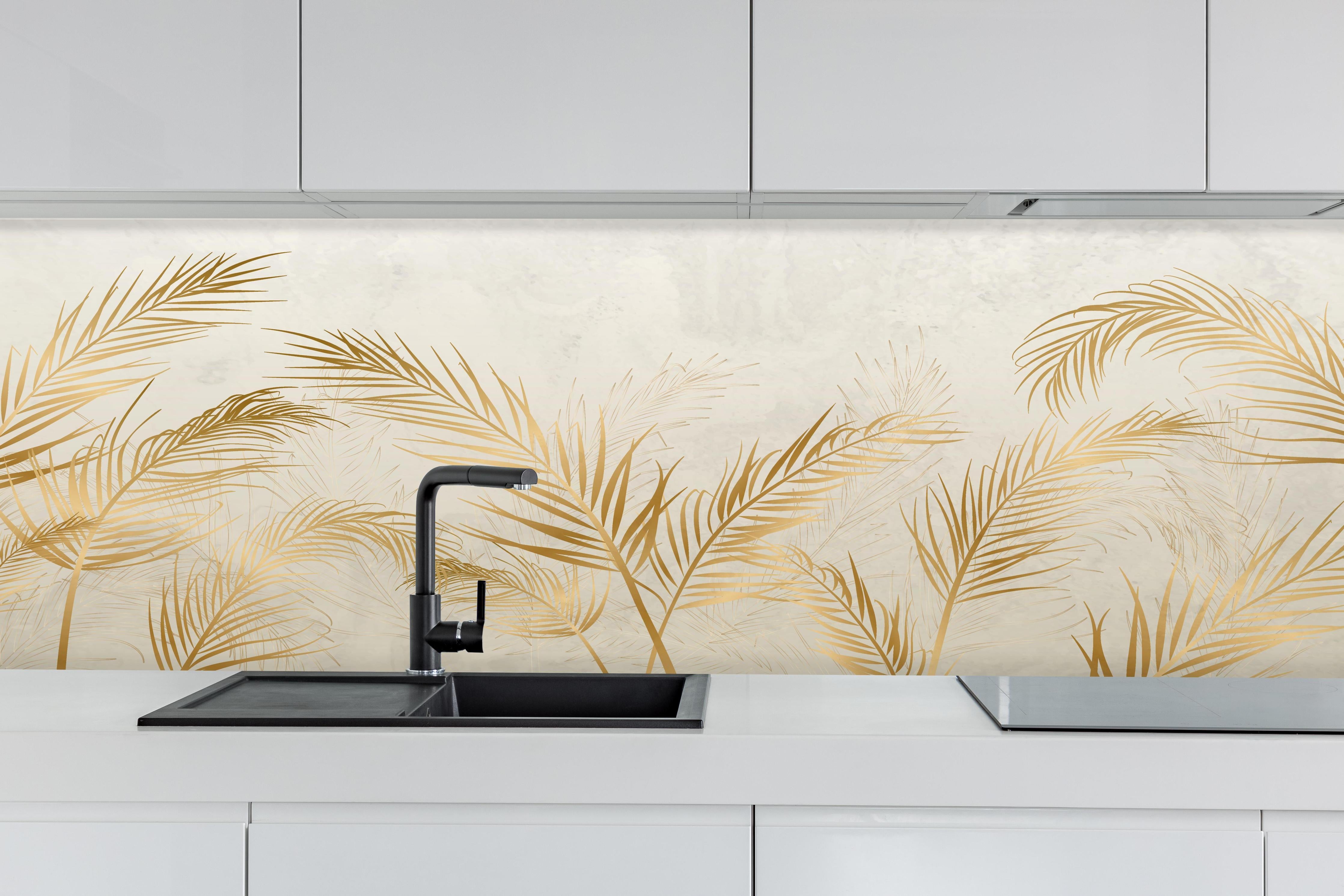 Küche - Elegante goldene Palmwedel auf hellem Grund hinter weißen Hochglanz-Küchenregalen und schwarzem Wasserhahn