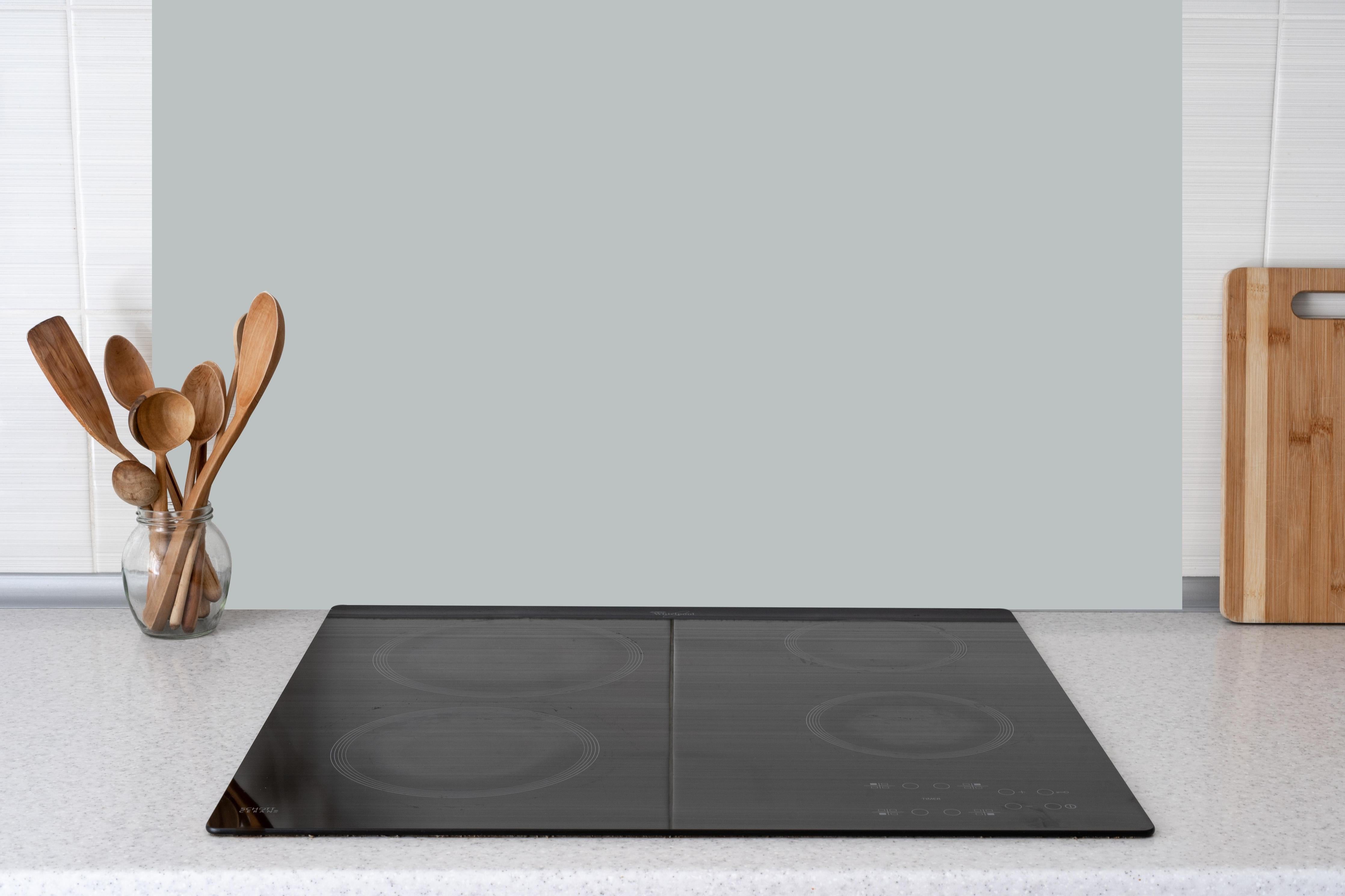 Küche - Elegante graue Betontextur hinter weißen Hochglanz-Küchenregalen und schwarzem Wasserhahn