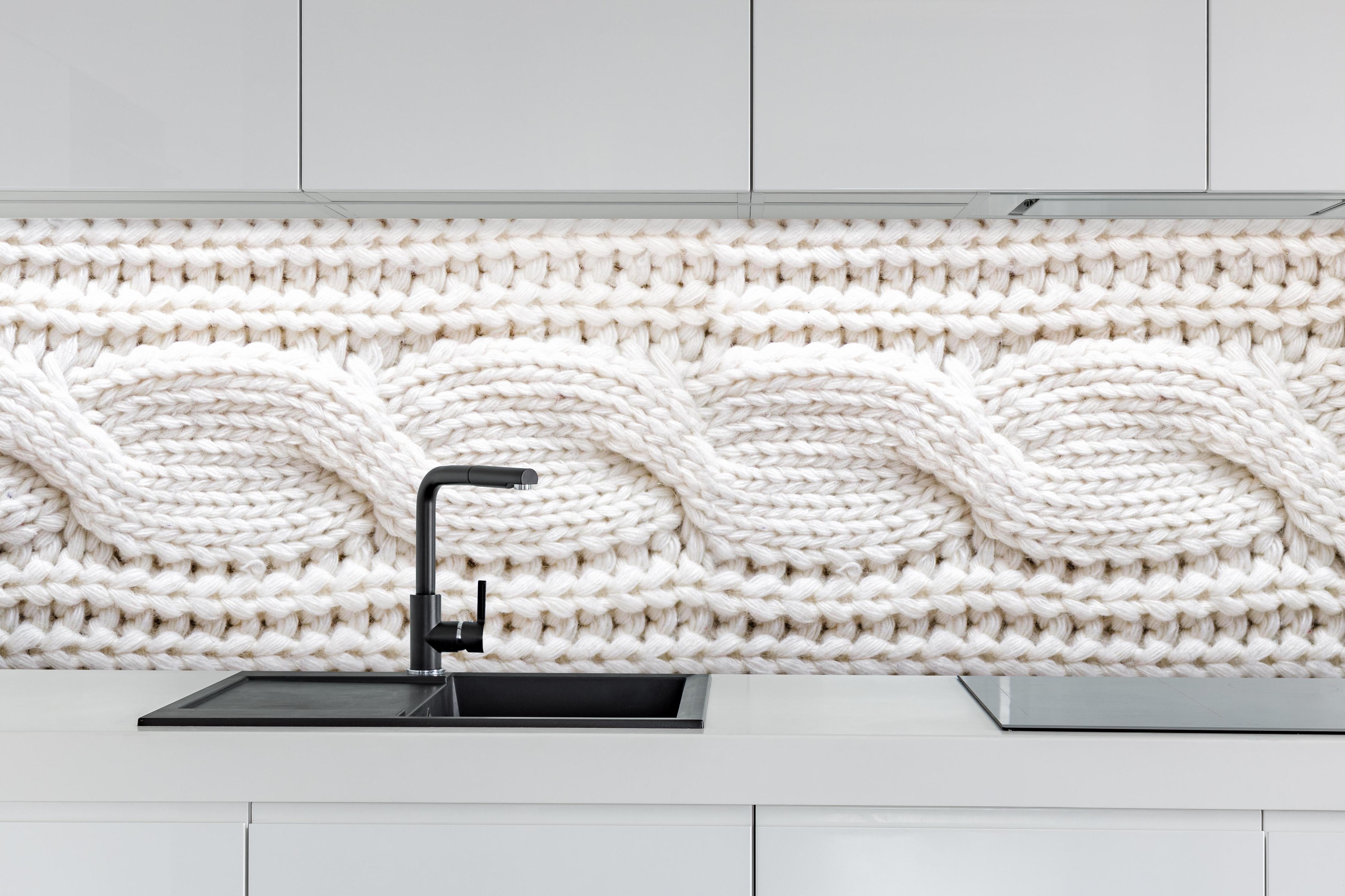 Küche - Elegante weiße Stricktextur aus Wolle hinter weißen Hochglanz-Küchenregalen und schwarzem Wasserhahn