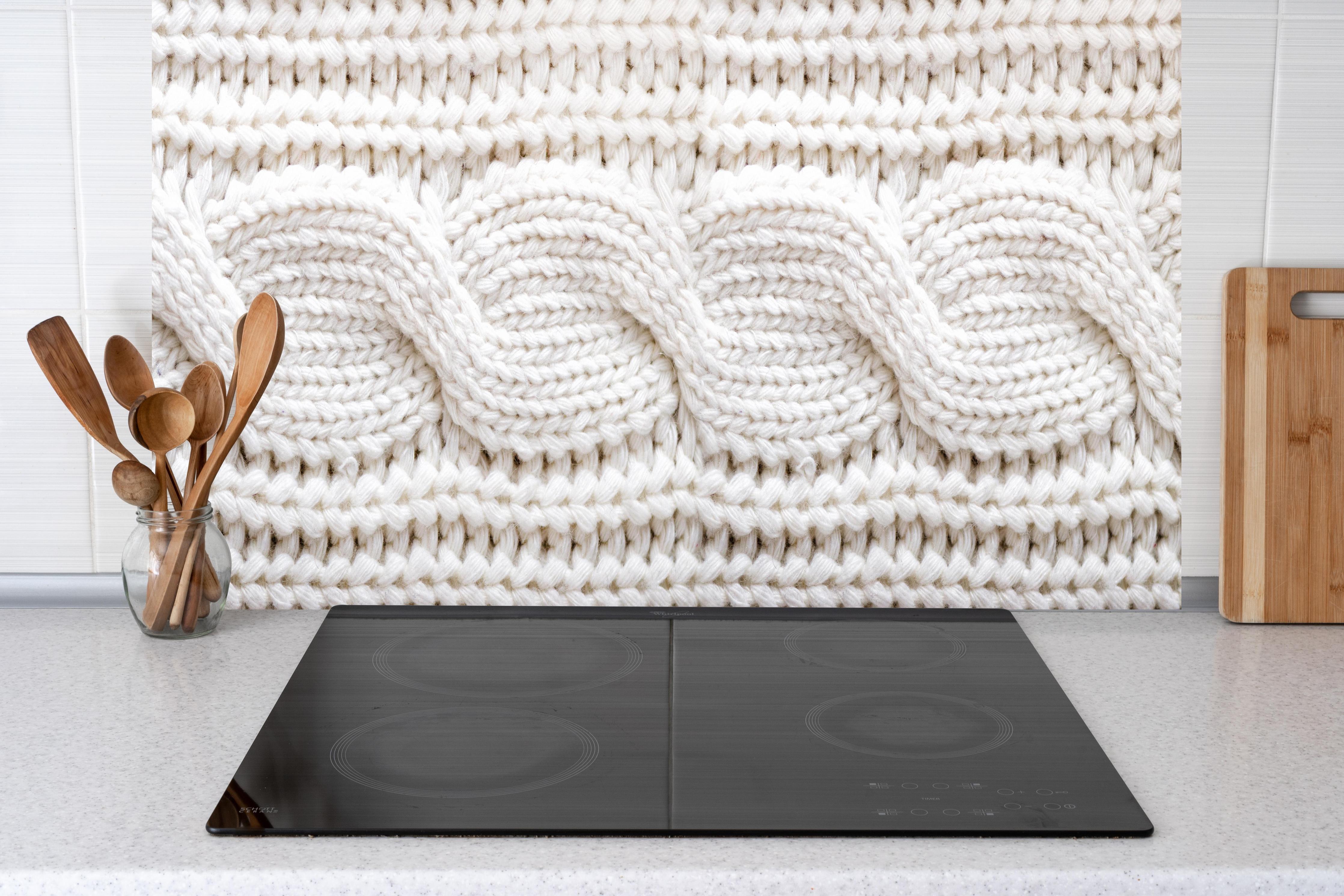 Küche - Elegante weiße Stricktextur aus Wolle hinter weißen Hochglanz-Küchenregalen und schwarzem Wasserhahn