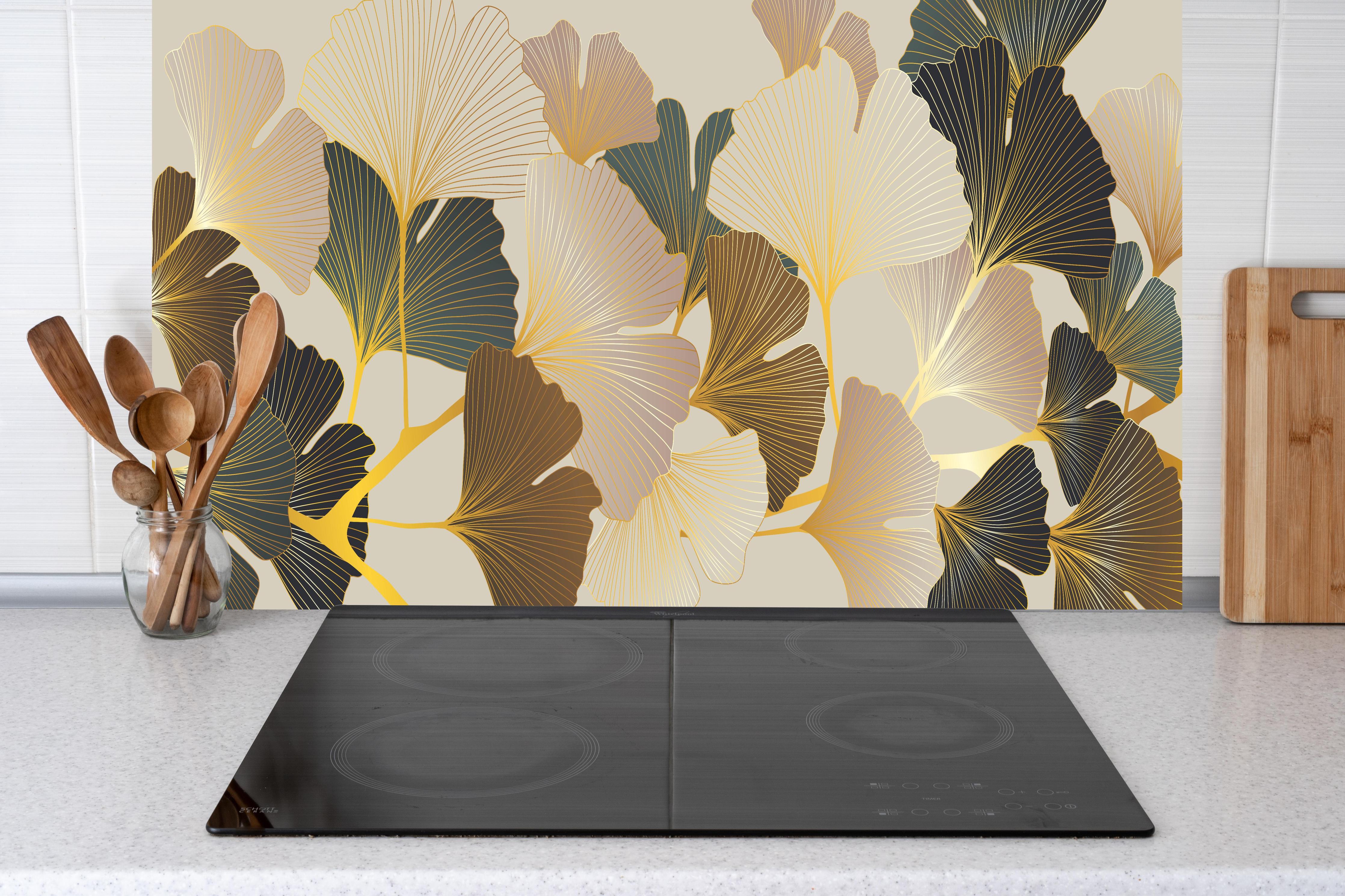 Küche - Elegantes Ginkgo-Blattmotiv mit goldfarbenen Akzenten hinter weißen Hochglanz-Küchenregalen und schwarzem Wasserhahn